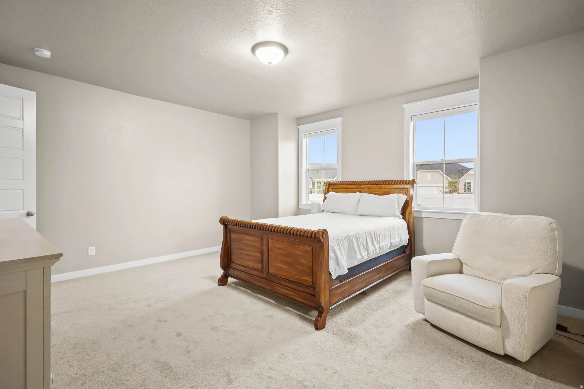 Primary Bedroom featuring a textured ceiling and light carpet