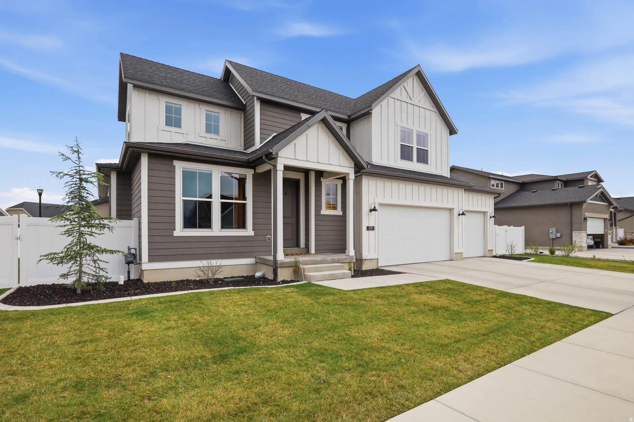 View of front facade with board and batten siding, a shingled roof, driveway, a garage, and a gate