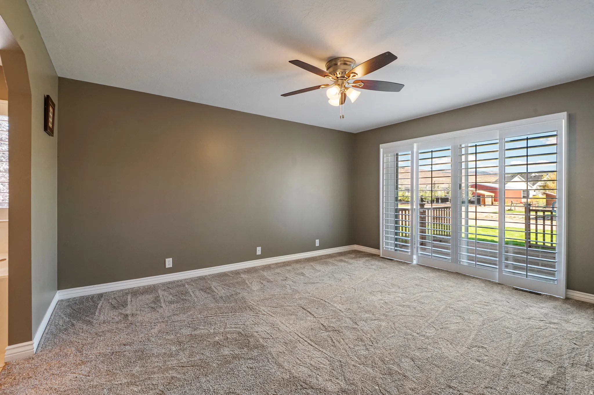 Unfurnished room featuring light colored carpet and ceiling fan