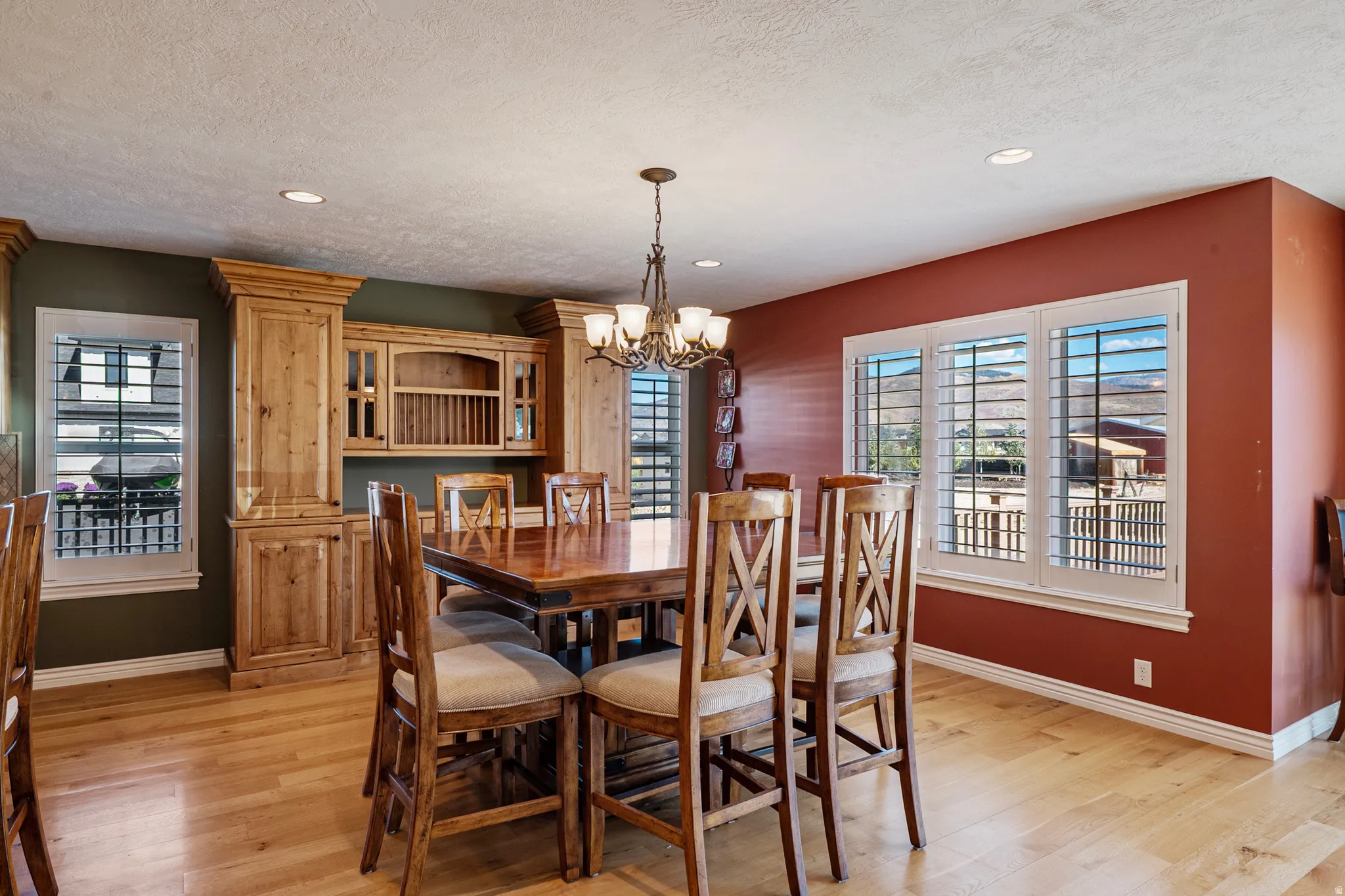 Dining area featuring light wood-type flooring, hanging lights, and a textured ceiling
