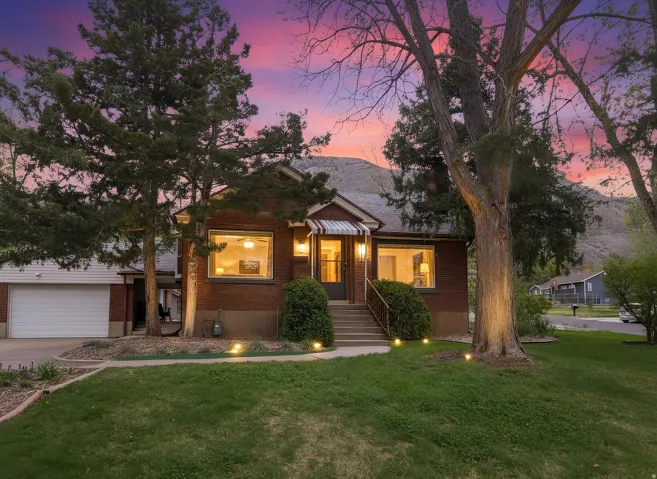 View of front of house with a front lawn, a garage, brick siding, and concrete driveway