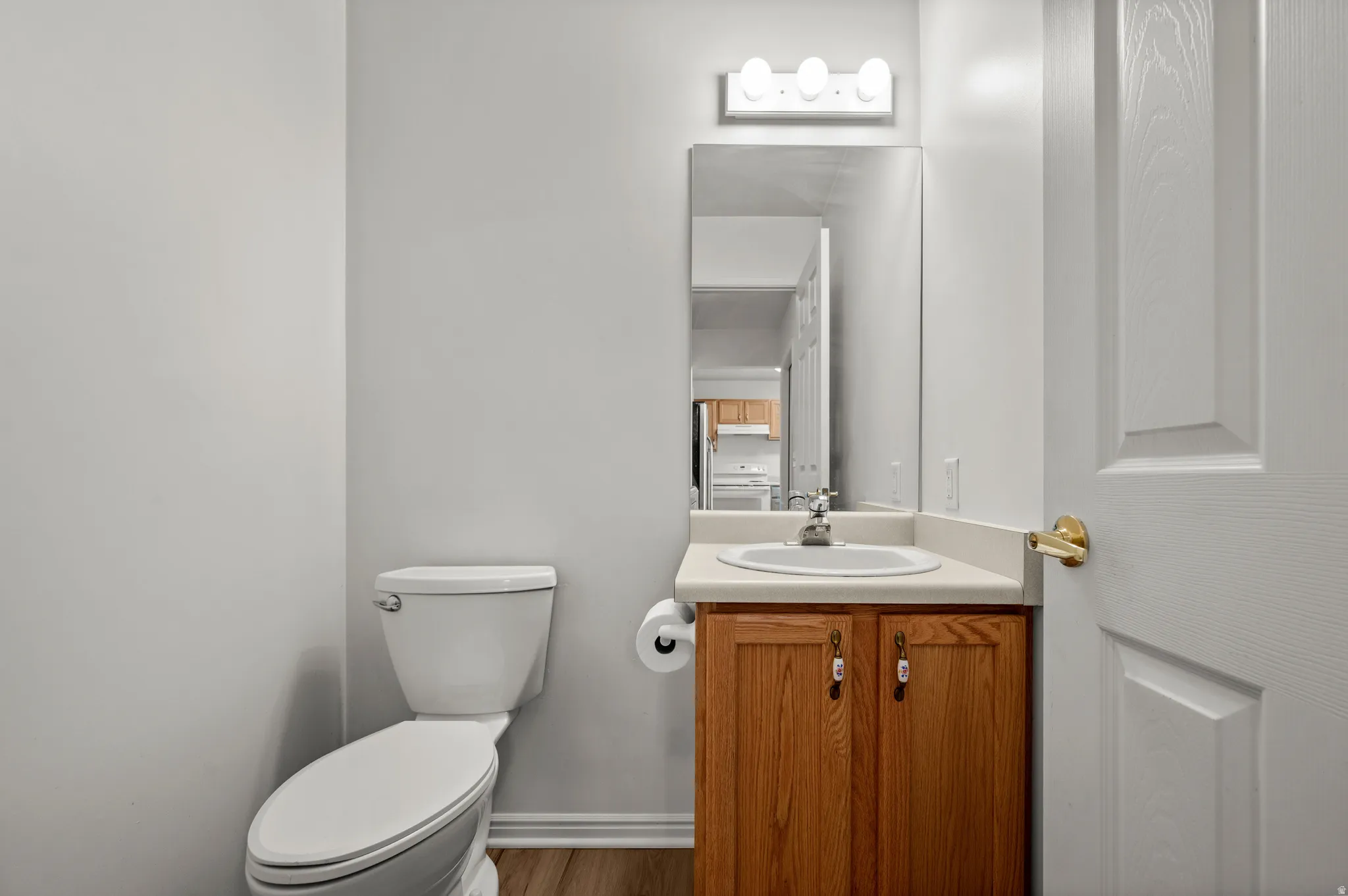 Bathroom with vanity, dark wood finished floors, and washer / clothes dryer