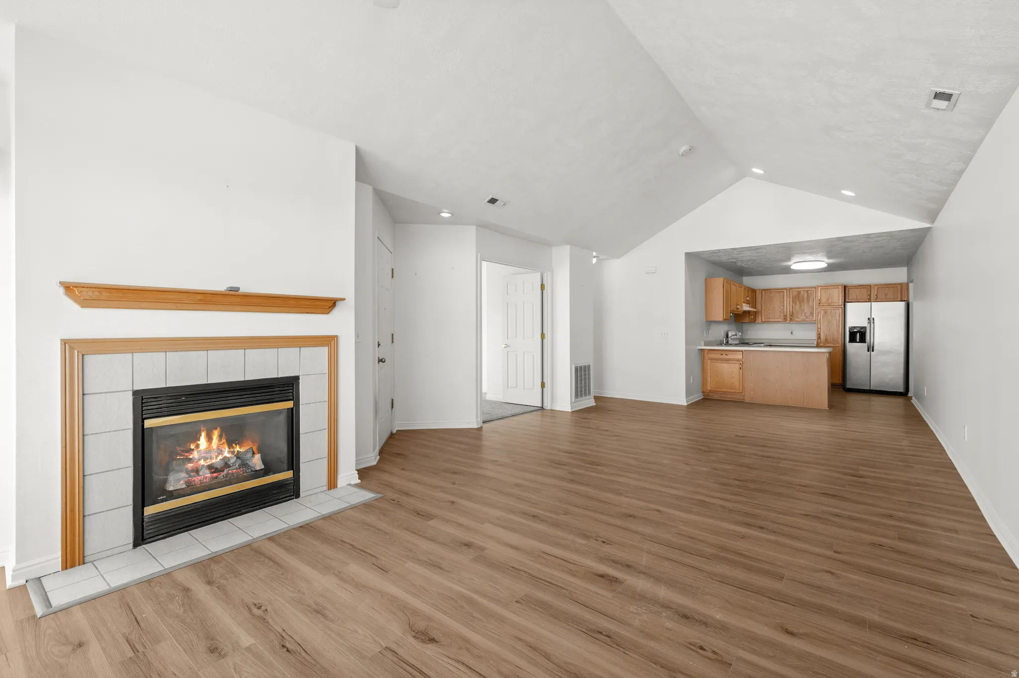 Unfurnished living room with a tile fireplace, light wood-type flooring, and recessed lighting