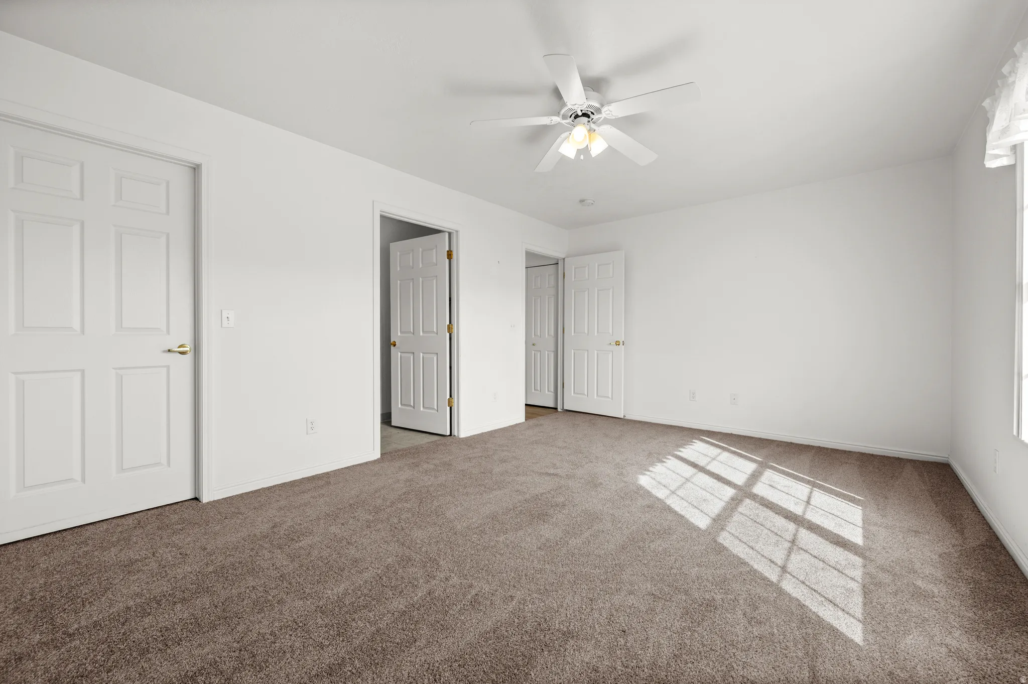 Unfurnished bedroom with carpet and ceiling fan