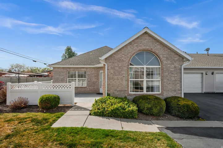 Ranch-style house with brick siding, an attached garage, roof with shingles, and asphalt driveway