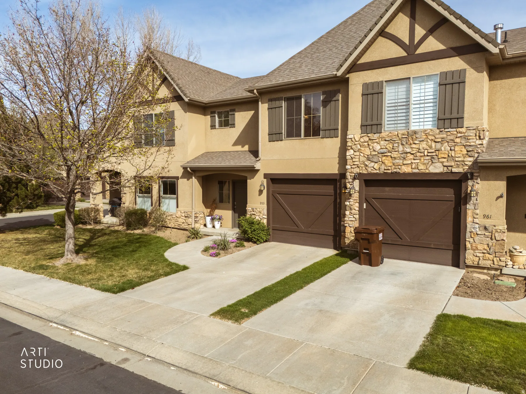 View of front of house featuring stucco siding, driveway, a garage, stone siding, and roof with shingles