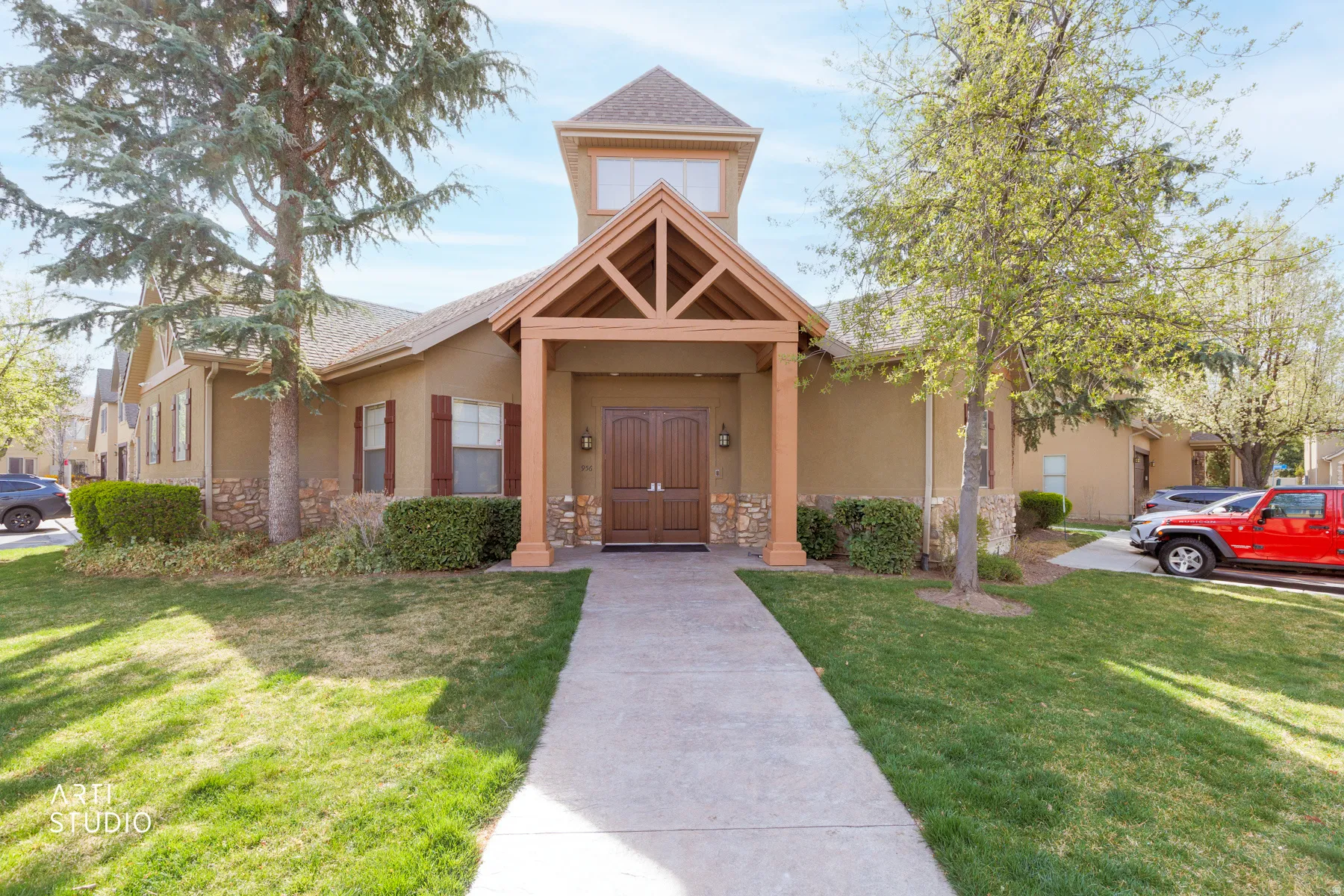 View of front of property with stucco siding, stone siding, and a front yard