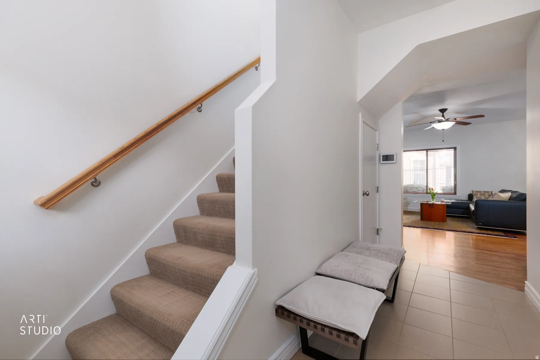Stairs with a ceiling fan and tile patterned floors