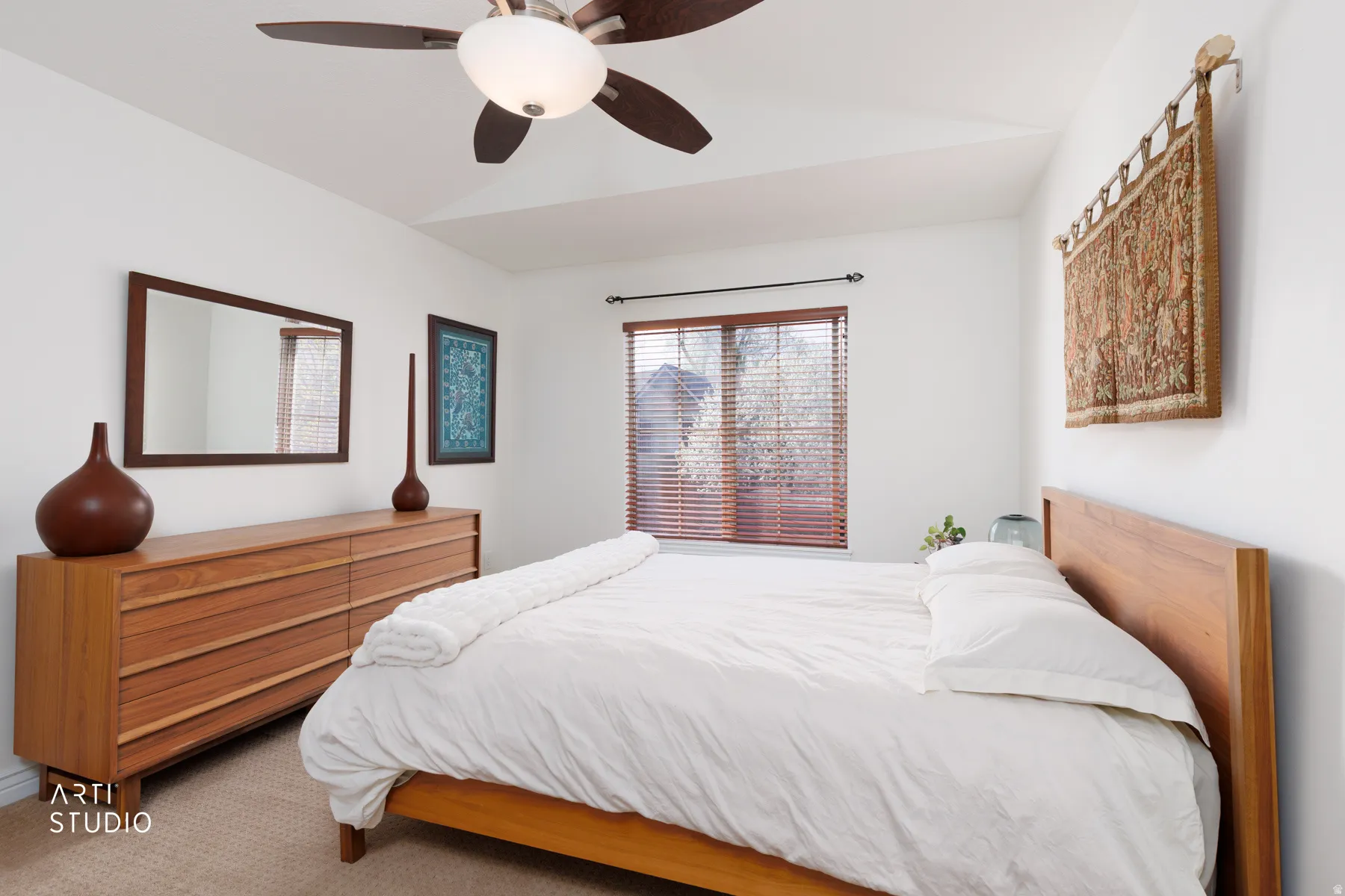 Carpeted bedroom with a ceiling fan and lofted ceiling