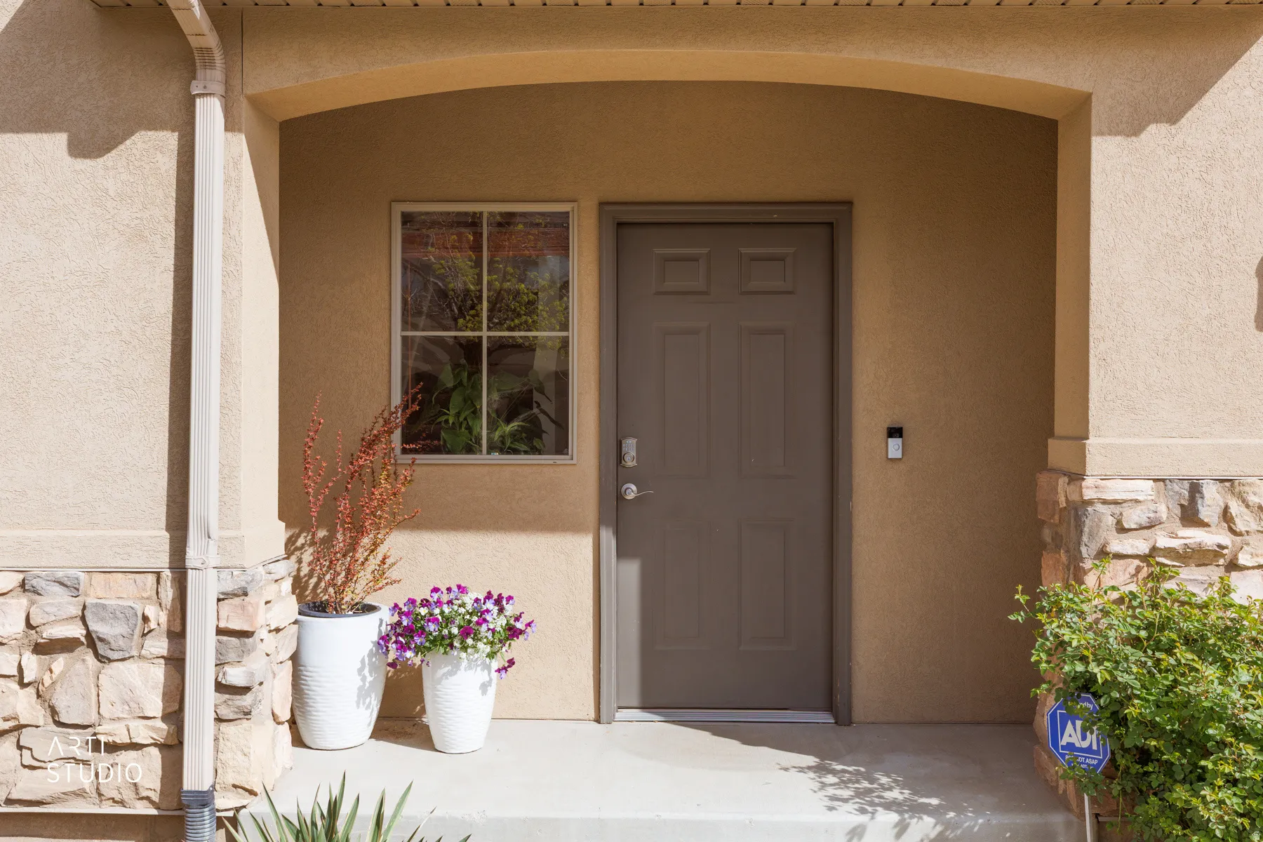 View of exterior entry with stone siding and stucco siding
