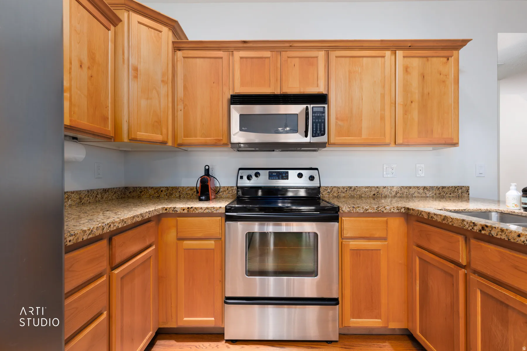 Kitchen featuring stainless steel appliances and light stone counters