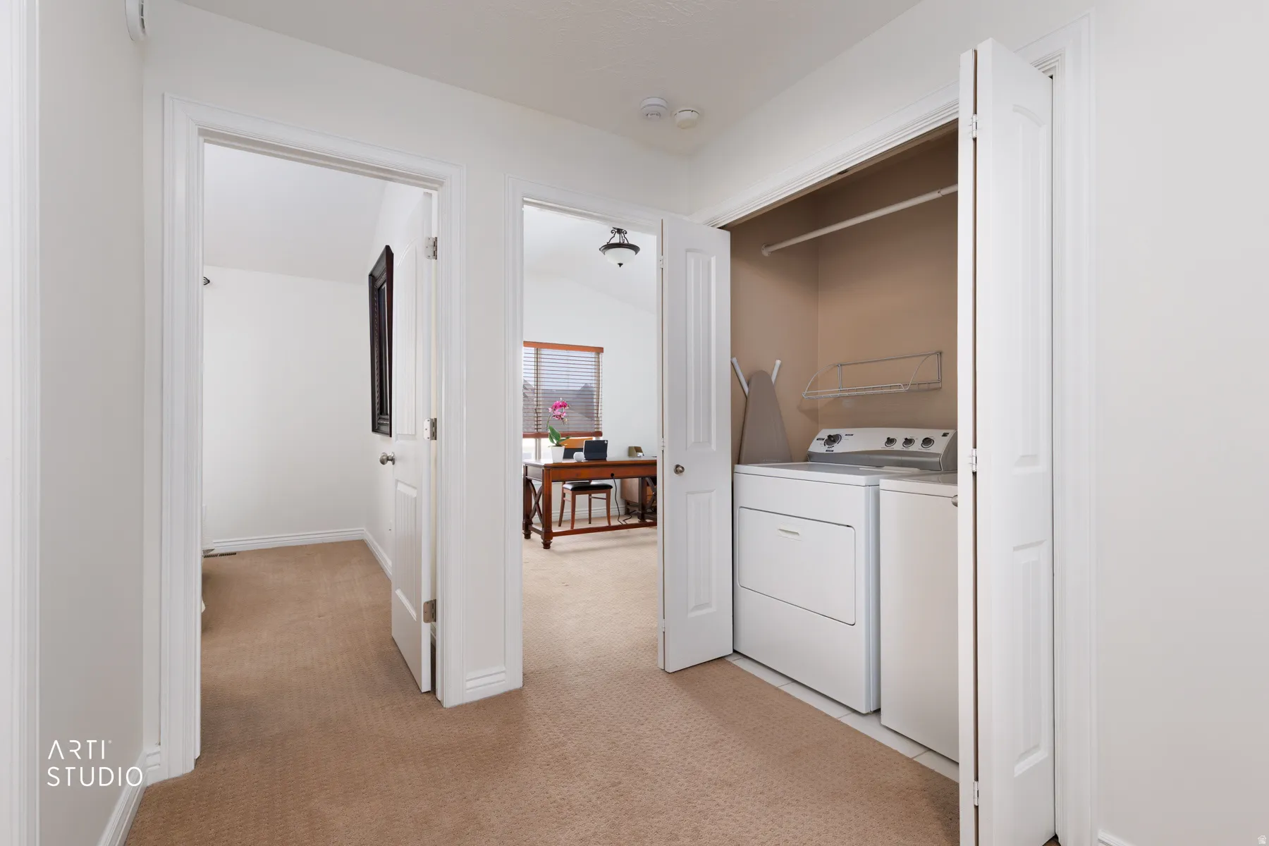 Laundry area with light colored carpet and washing machine and clothes dryer