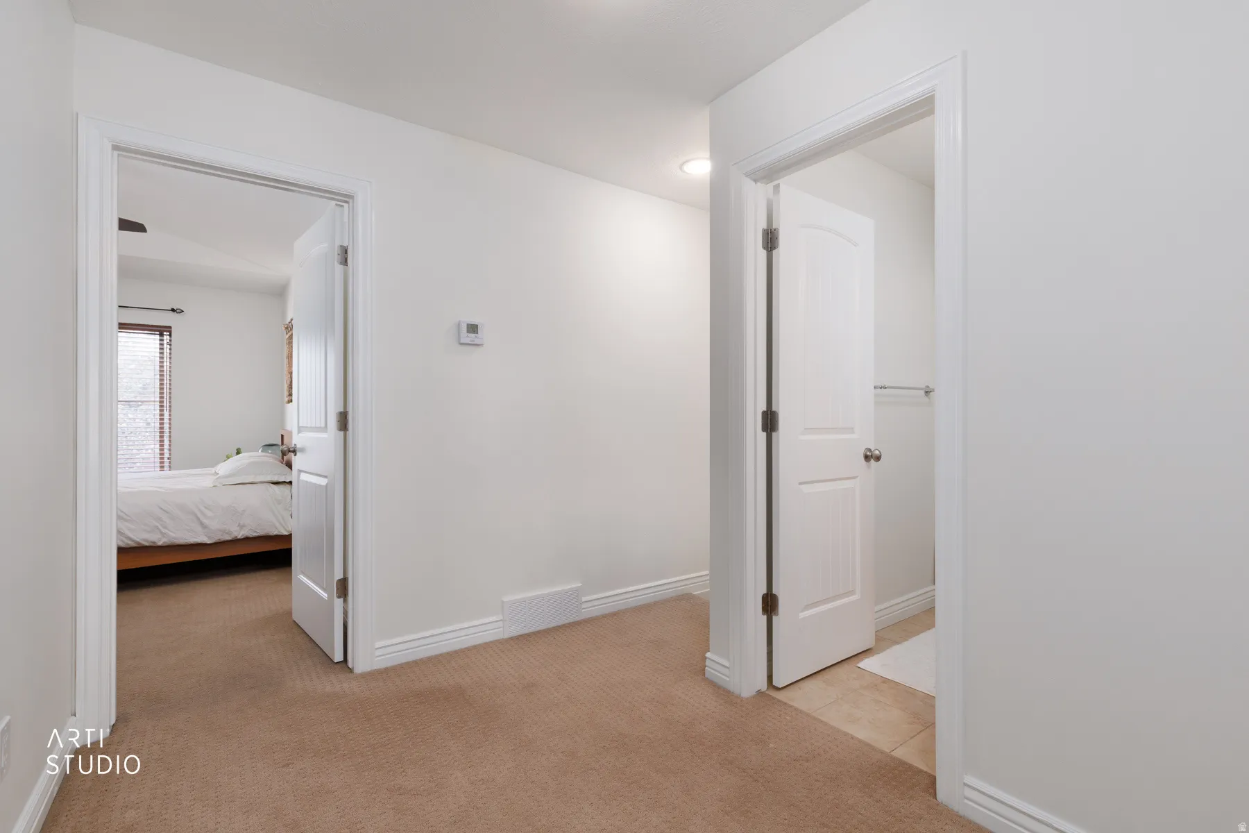 Corridor with light colored carpet and recessed lighting
