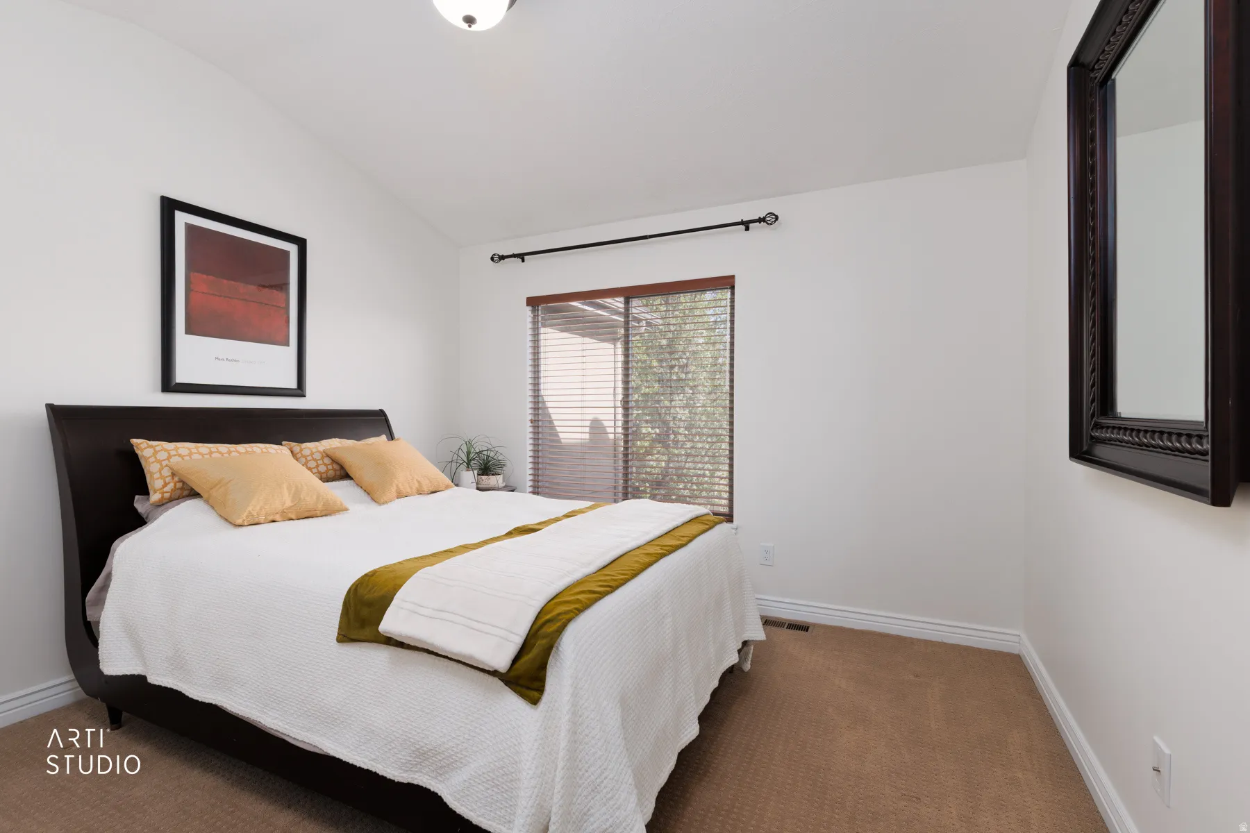 Carpeted bedroom featuring vaulted ceiling and baseboards