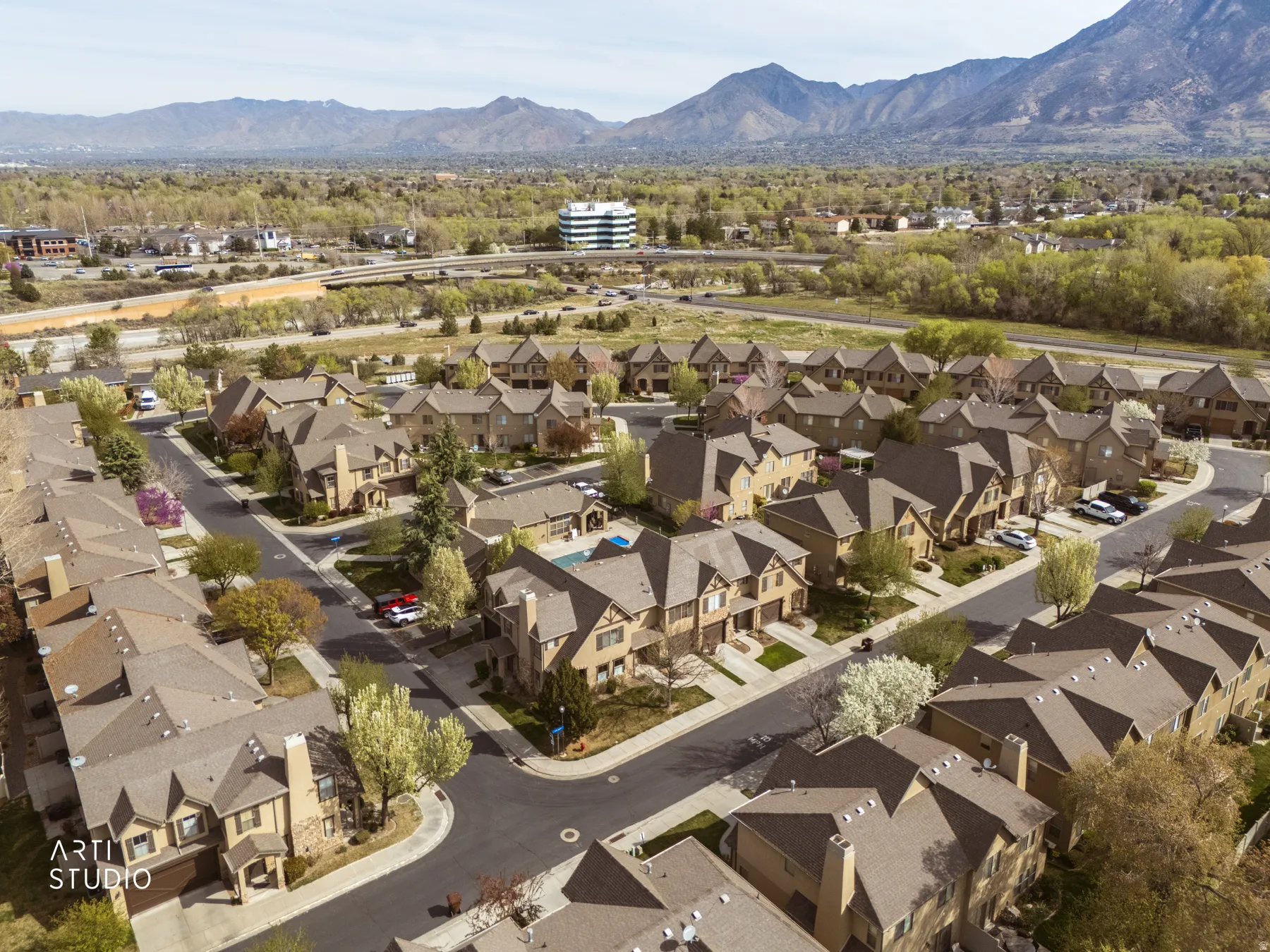 Aerial view of property's location with a mountainous background and nearby suburban area