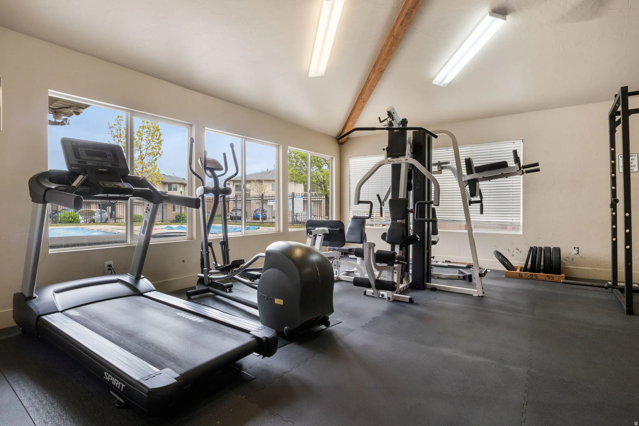 Workout area featuring vaulted ceiling with beams