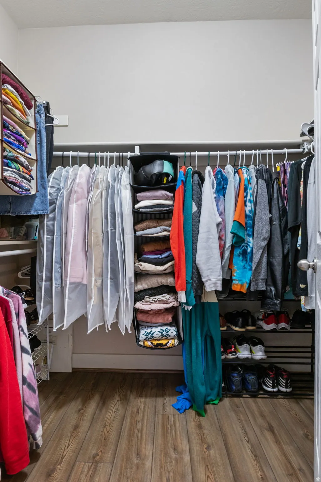 Walk in closet with light wood-type flooring