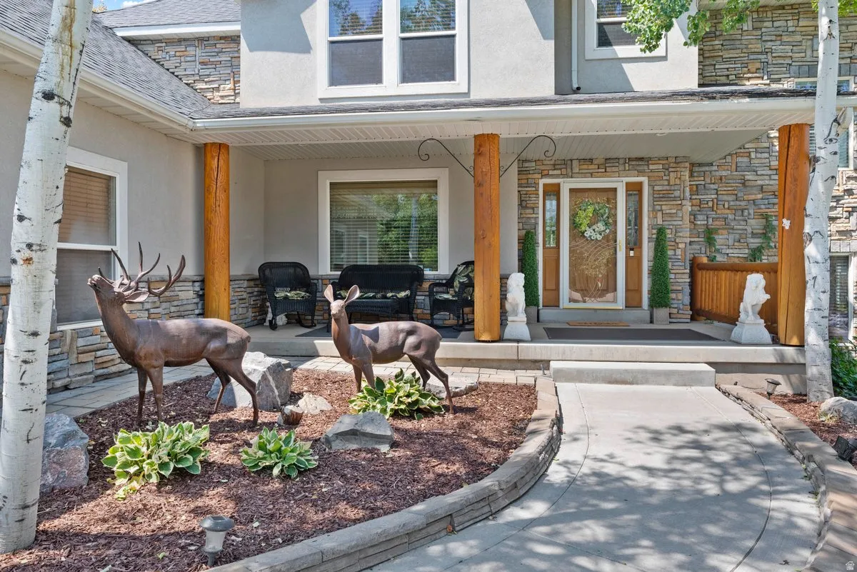 Property entrance with private walkway, custom beams and a spacious shaded covered porch