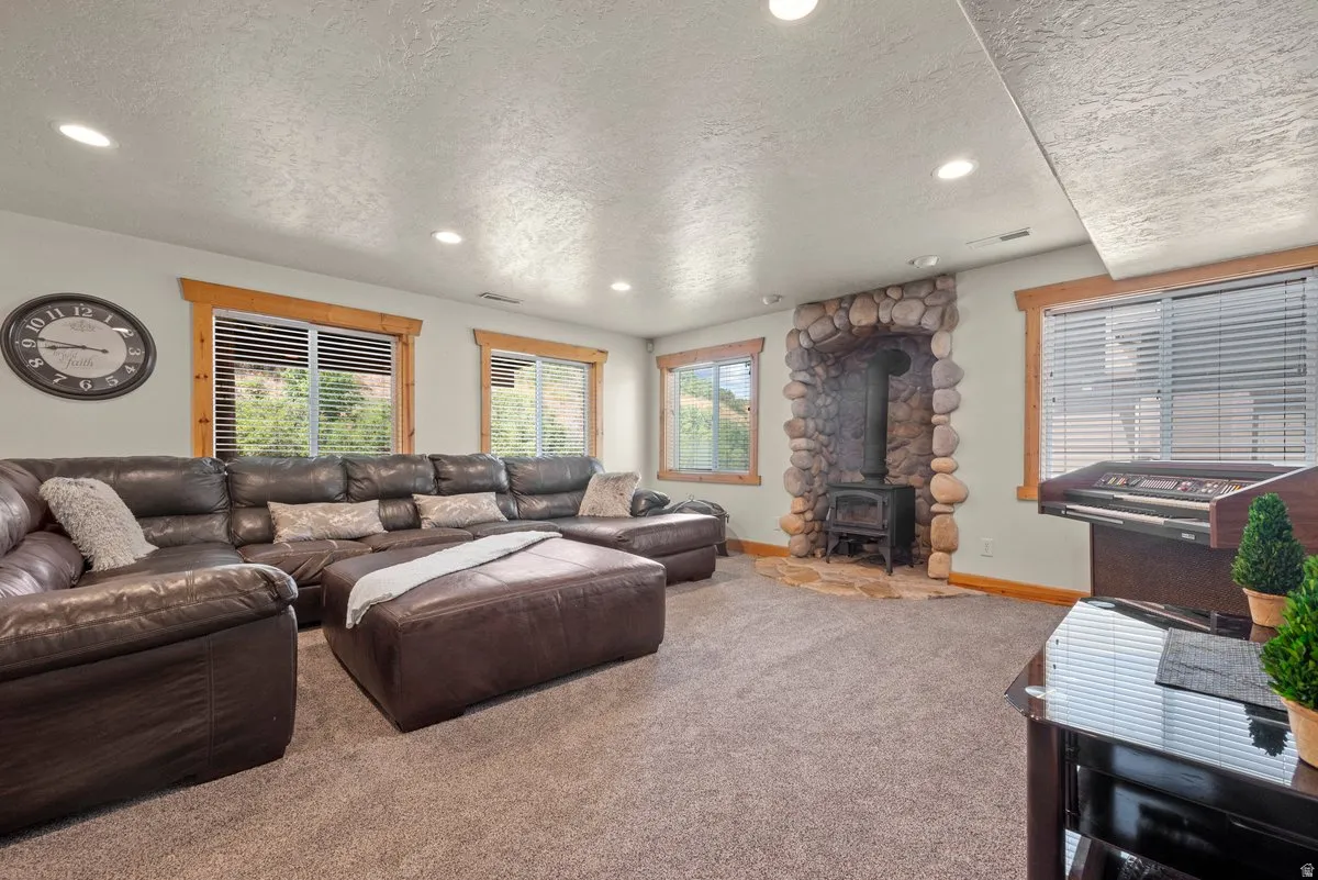 Massive windows offer natural light in the basement with a wood burning stove and custom wood trim