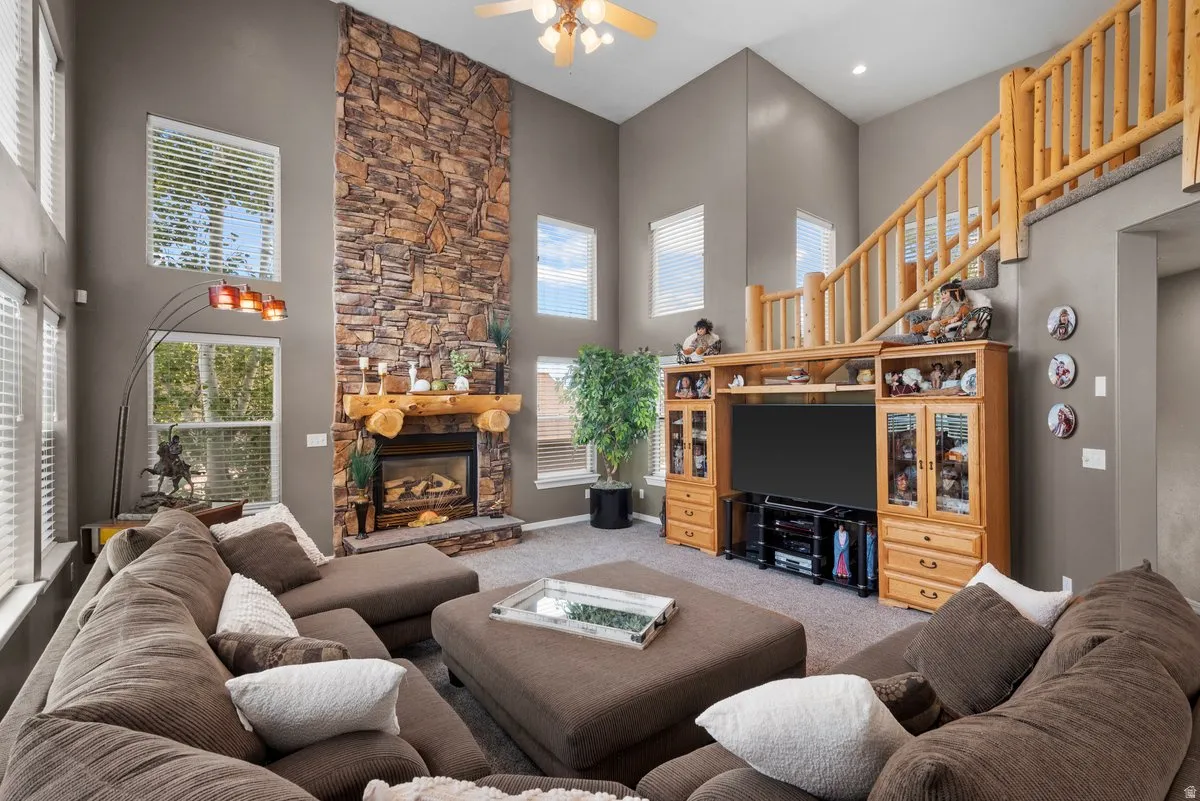 Vaulted ceilings, massive windows, a stone fireplace with majestic wood mantel and staircase
