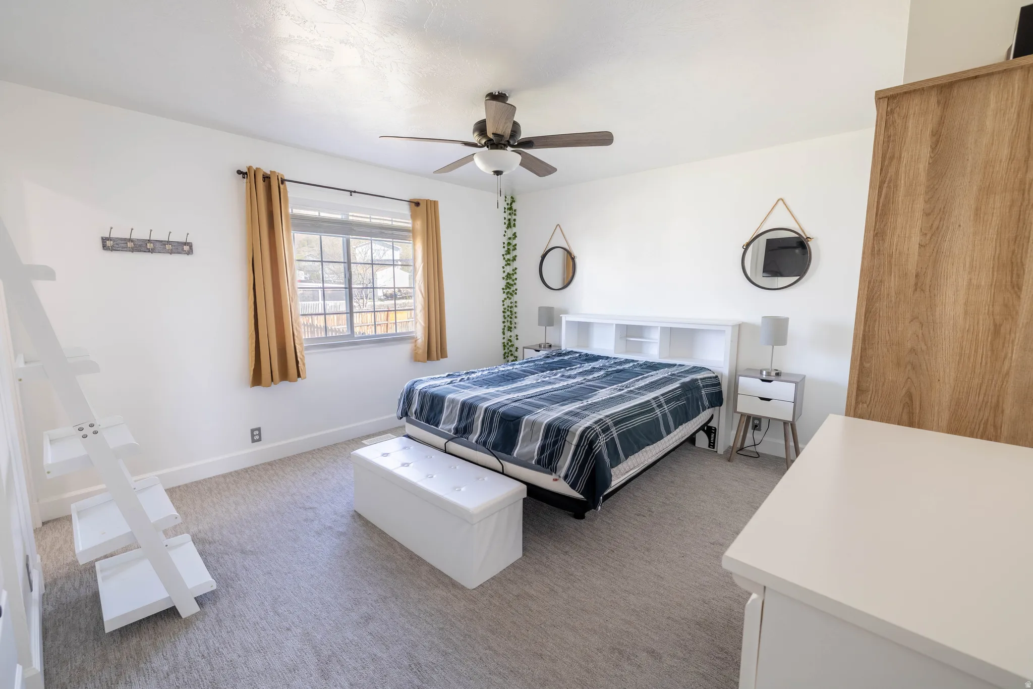 Bedroom featuring light colored carpet and a ceiling fan