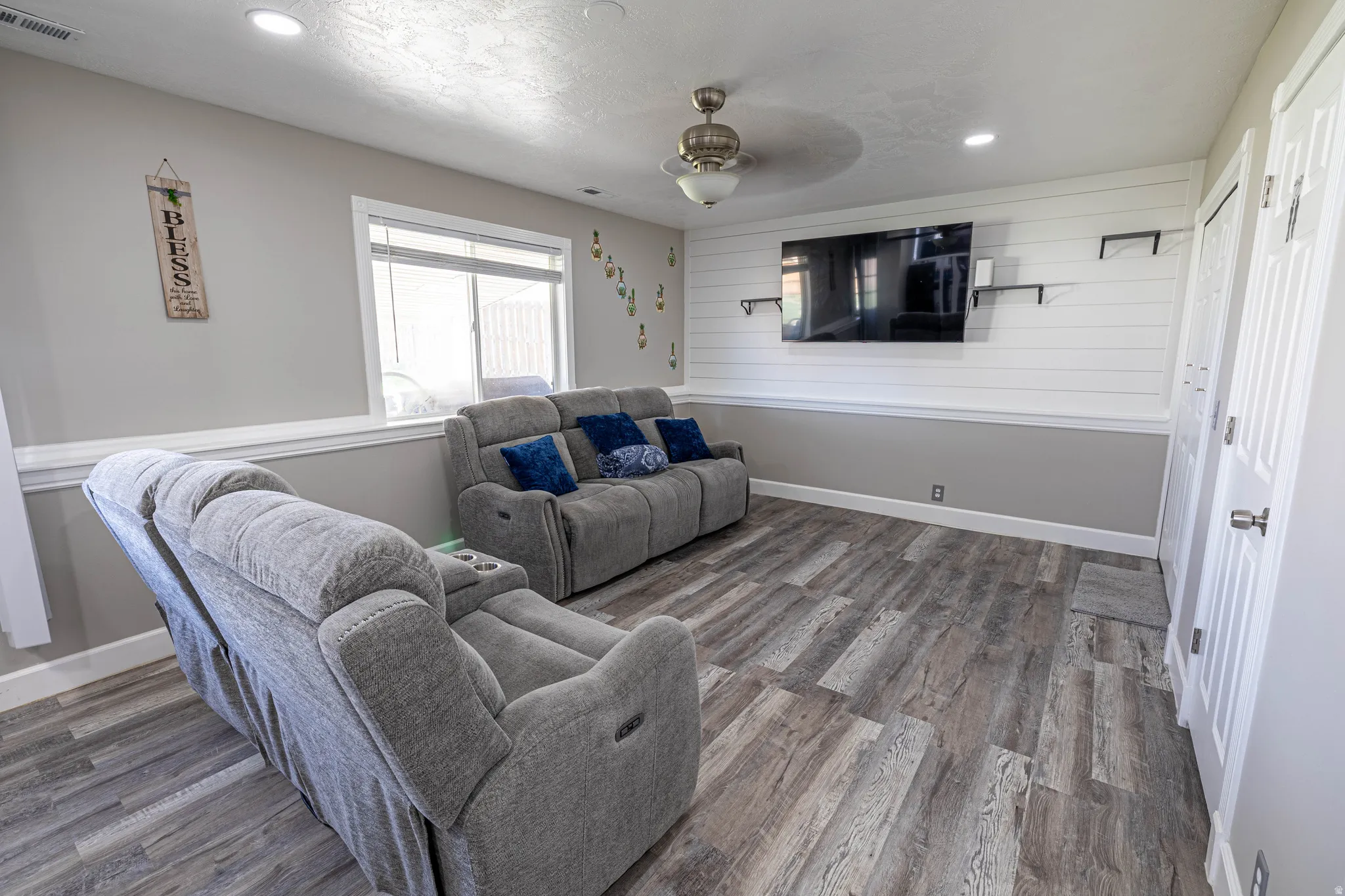 Living room with wood finished floors, recessed lighting, and a ceiling fan
