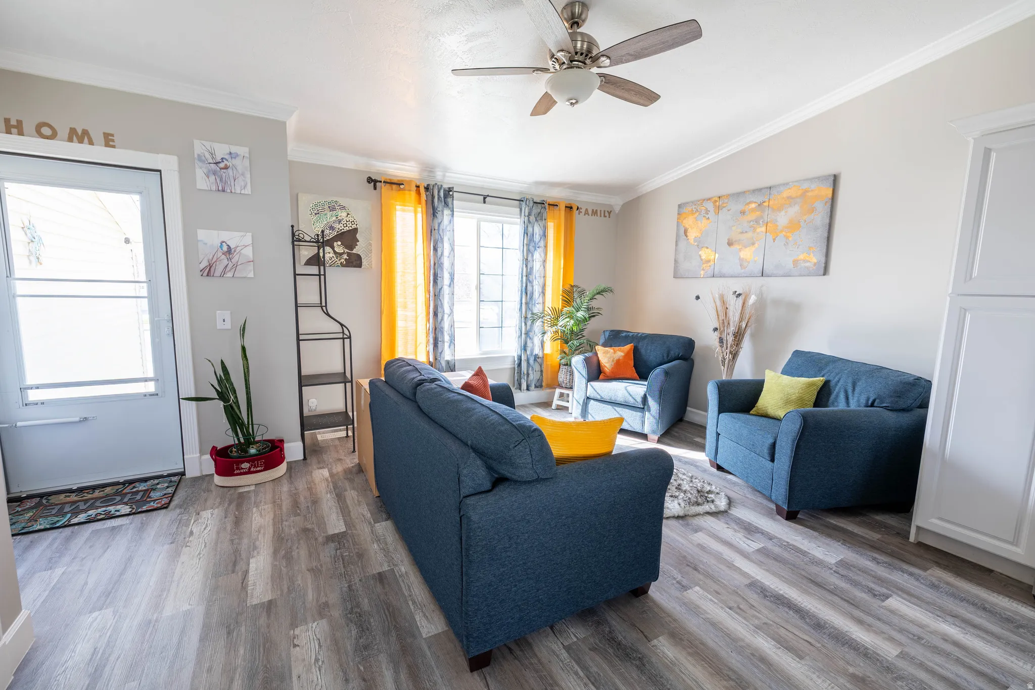 Living room featuring crown molding, wood finished floors, vaulted ceiling, and ceiling fan