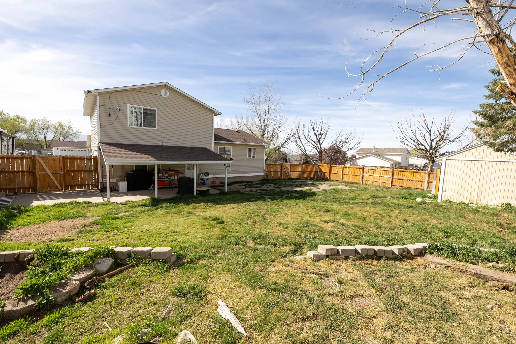 Back of property featuring a patio area, a fenced backyard, a gate, and an outdoor structure