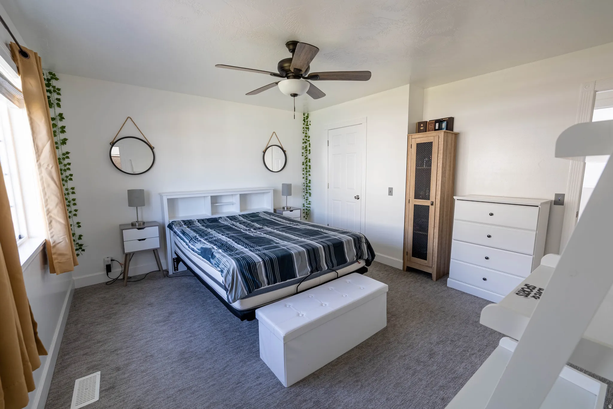Carpeted bedroom featuring ceiling fan and baseboards