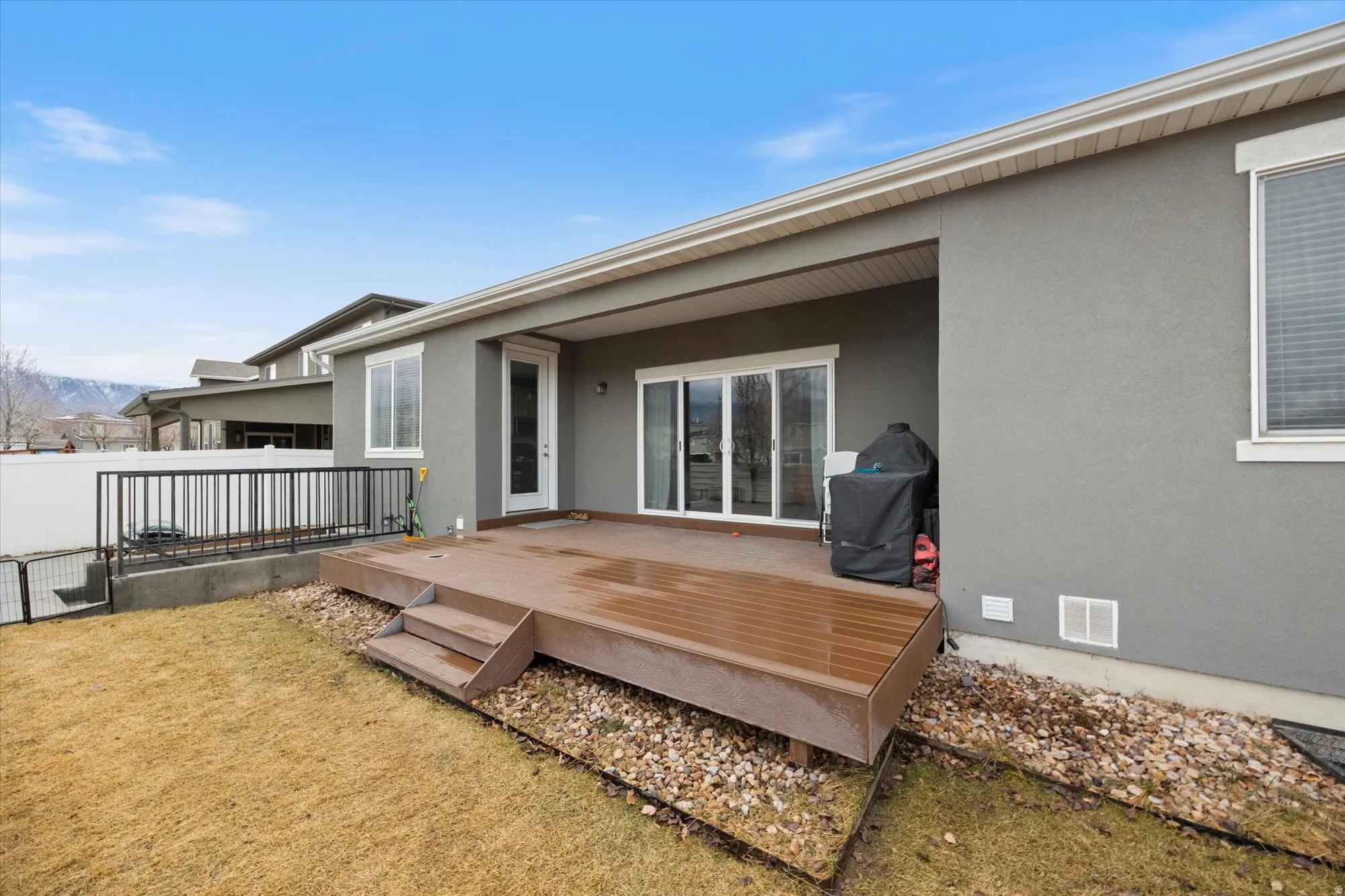 Rear view of property with stucco siding, a deck, and crawl space