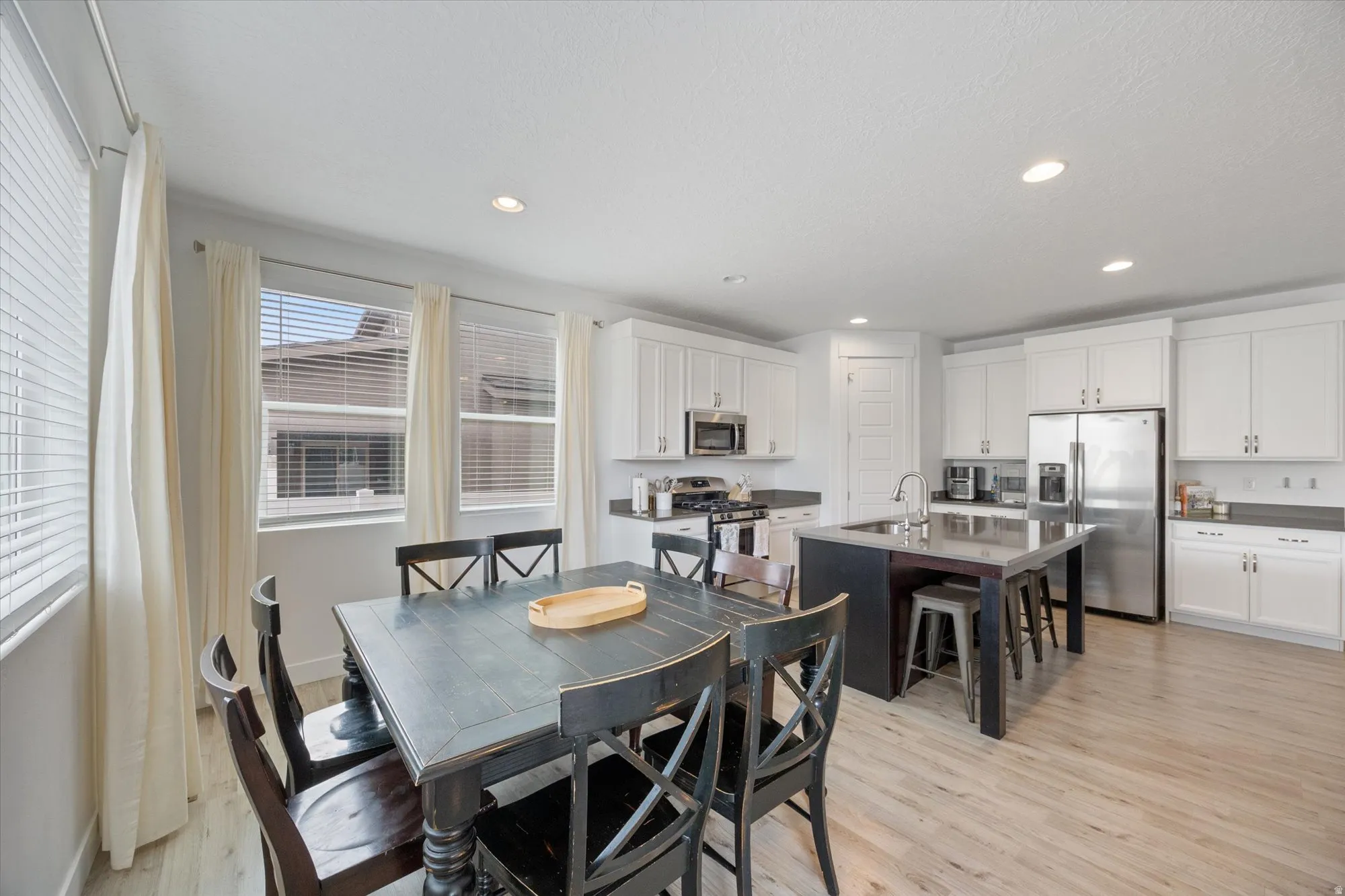 Dining area with light wood-type flooring and recessed lighting
