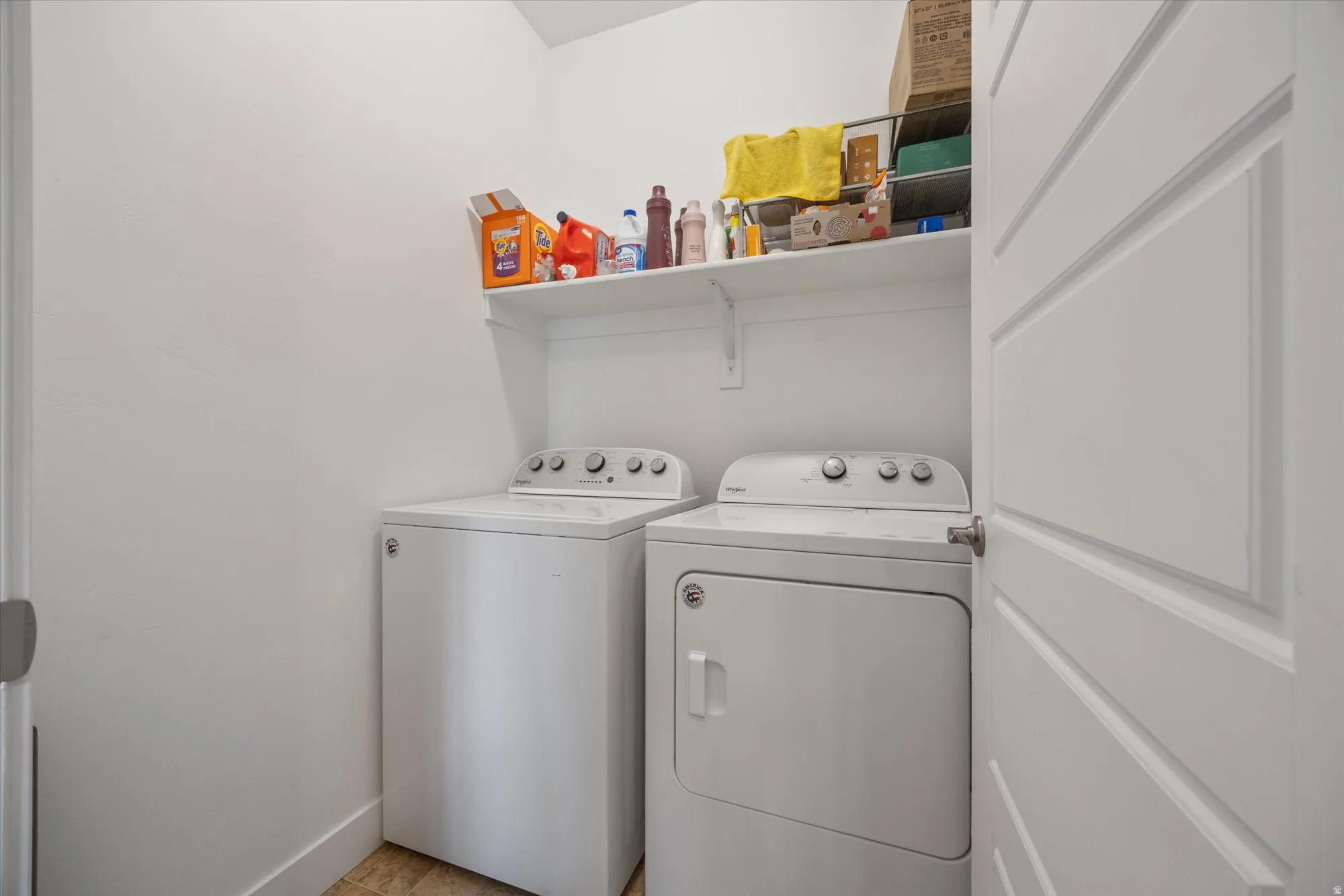 Laundry room with washing machine and clothes dryer and baseboards