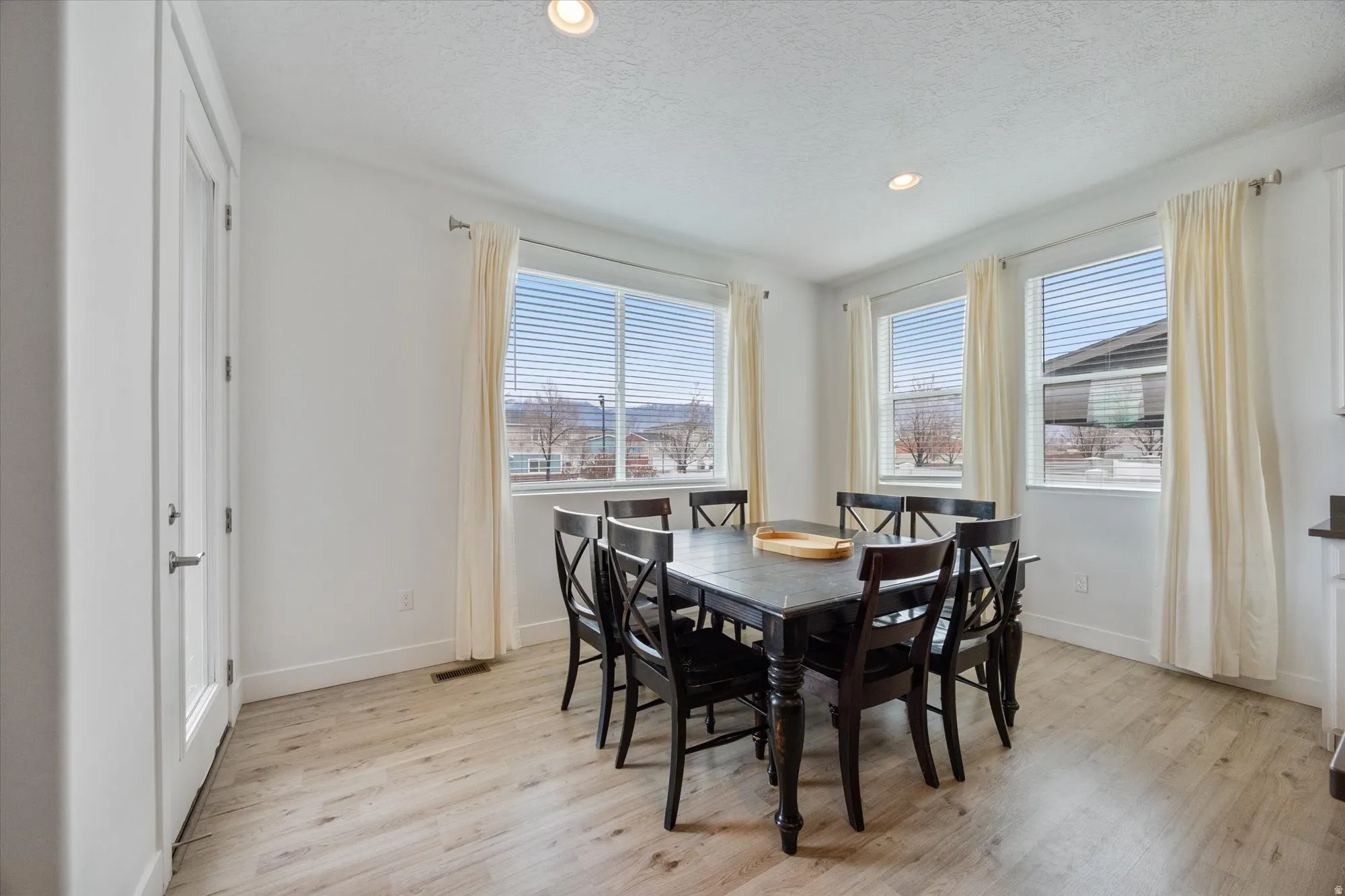 Dining area featuring light wood finished floors, recessed lighting, and a textured ceiling