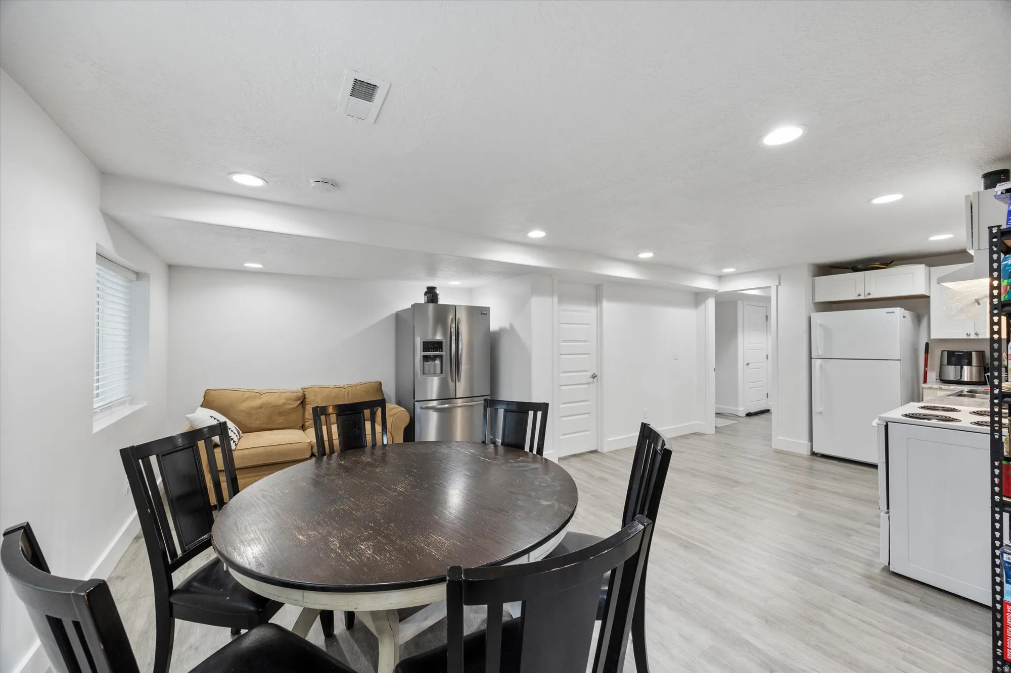 Dining area with light wood-type flooring, recessed lighting, and a textured ceiling