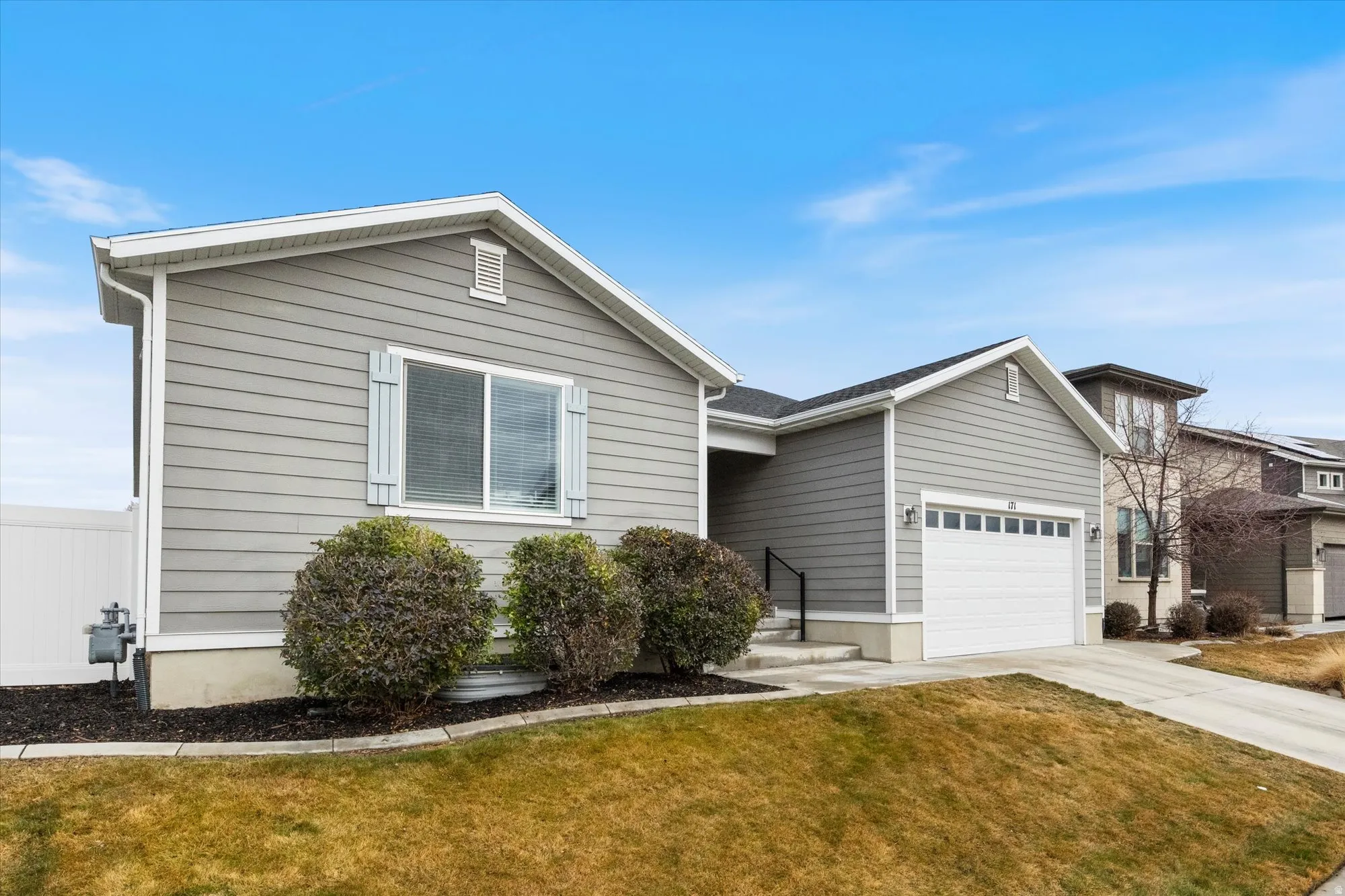 View of front of house with driveway, a front lawn, and an attached garage