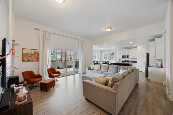 Living room with light wood-type flooring and recessed lighting