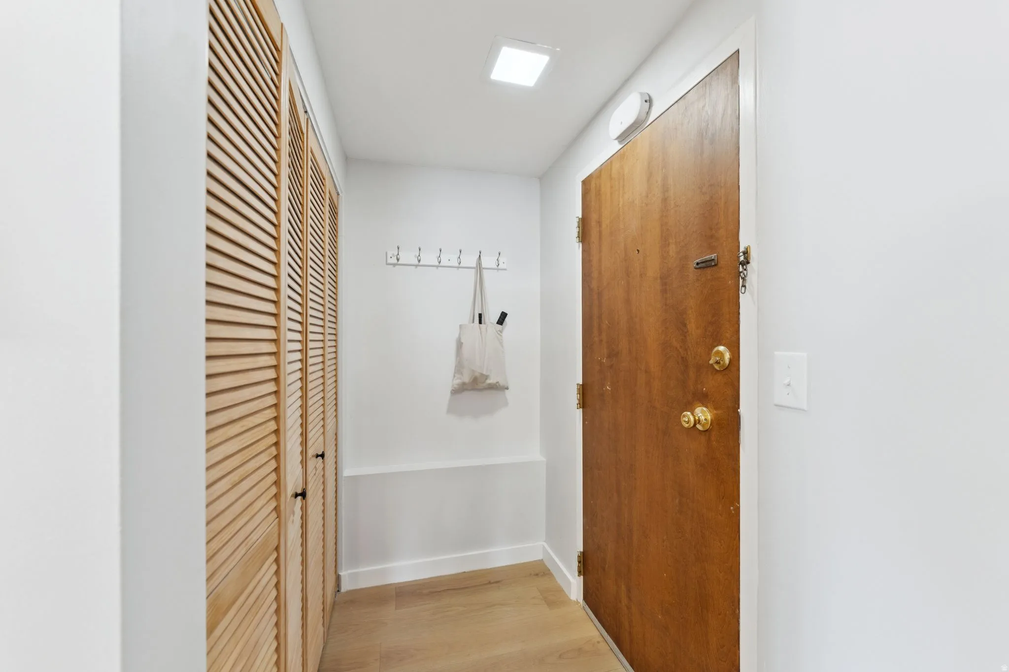 Corridor featuring light engineered wood-floors and baseboards