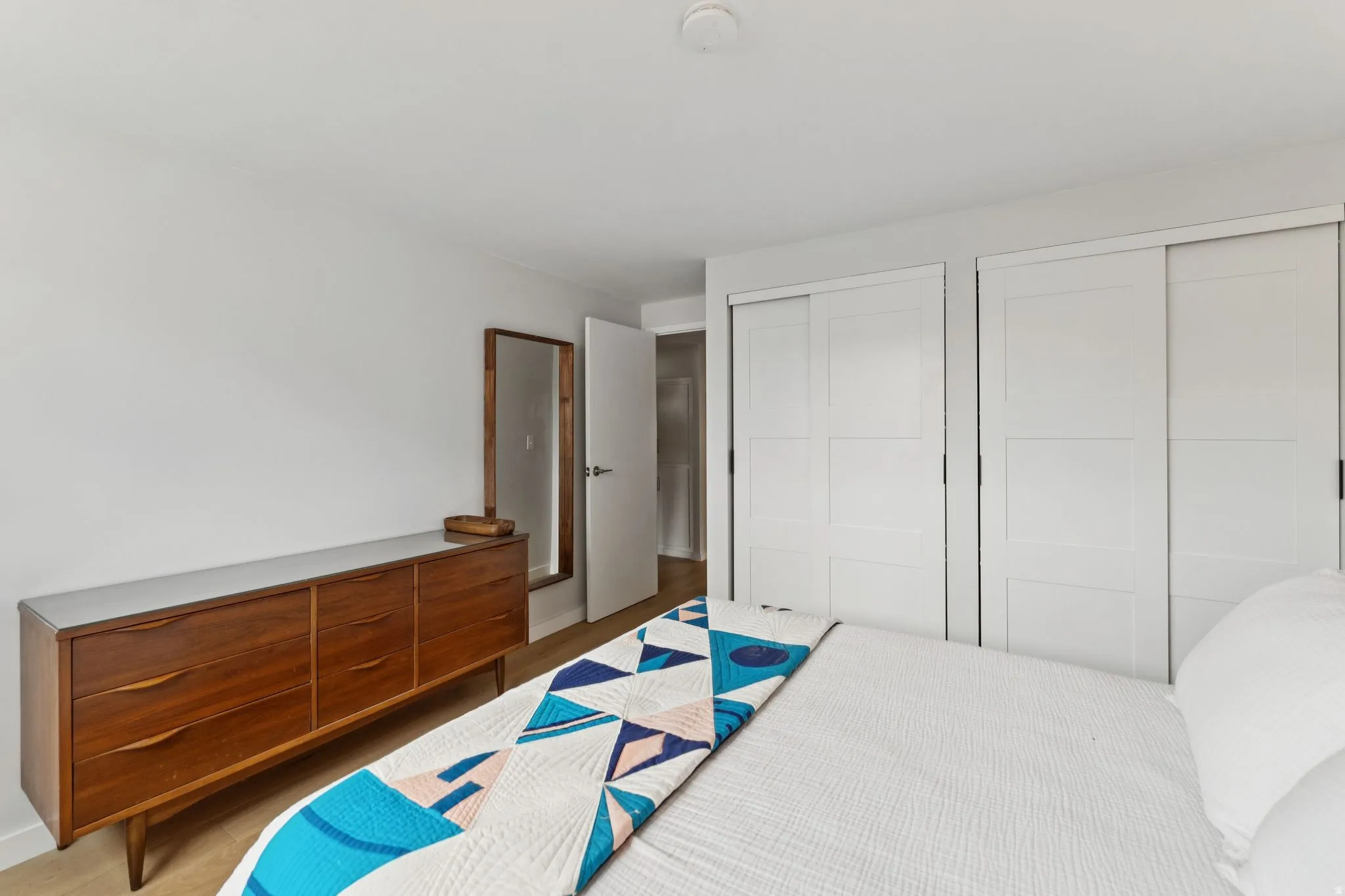 Bedroom with multiple closets and wood finished floors