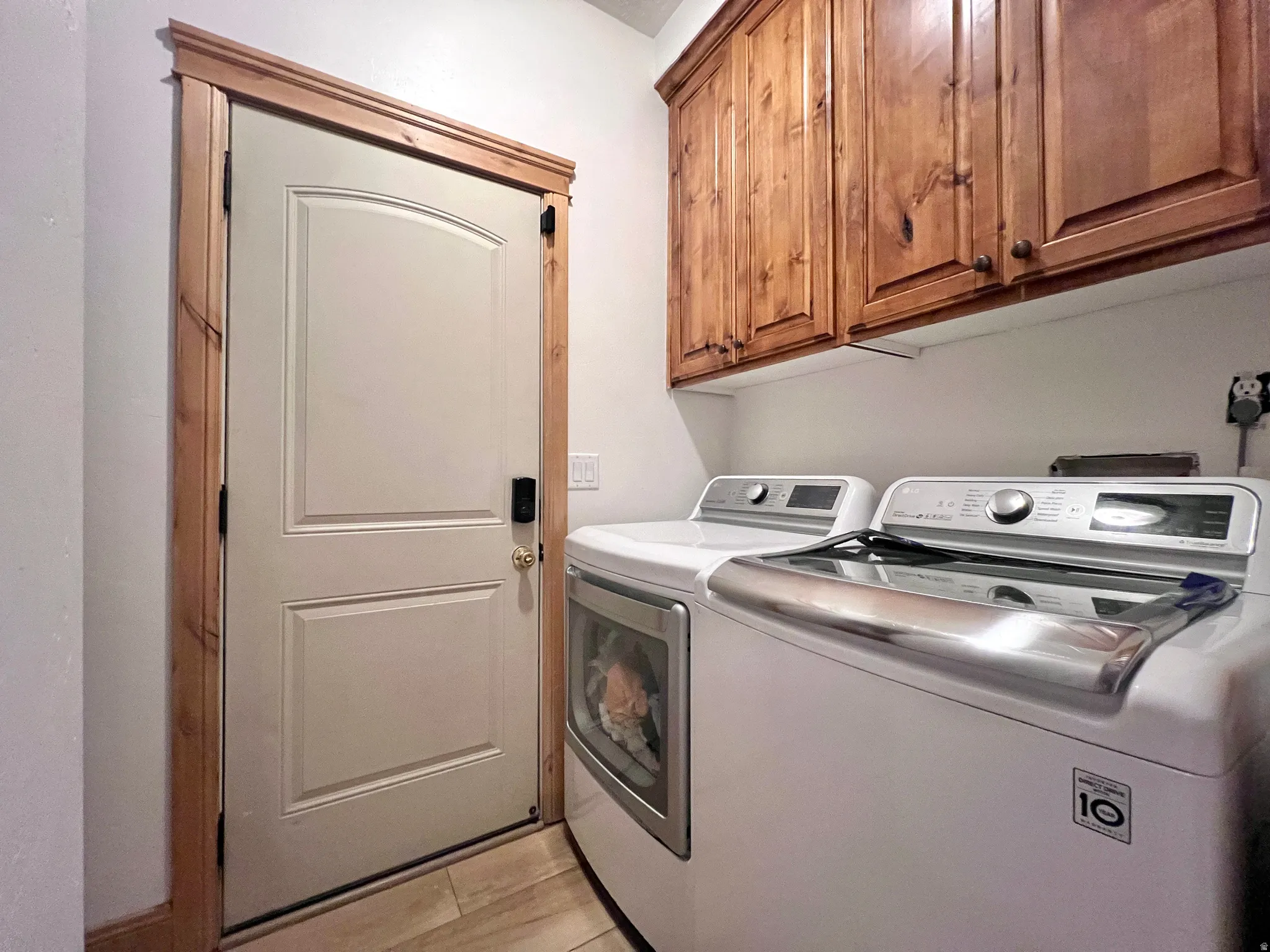 Laundry area featuring separate washer and dryer and cabinet space