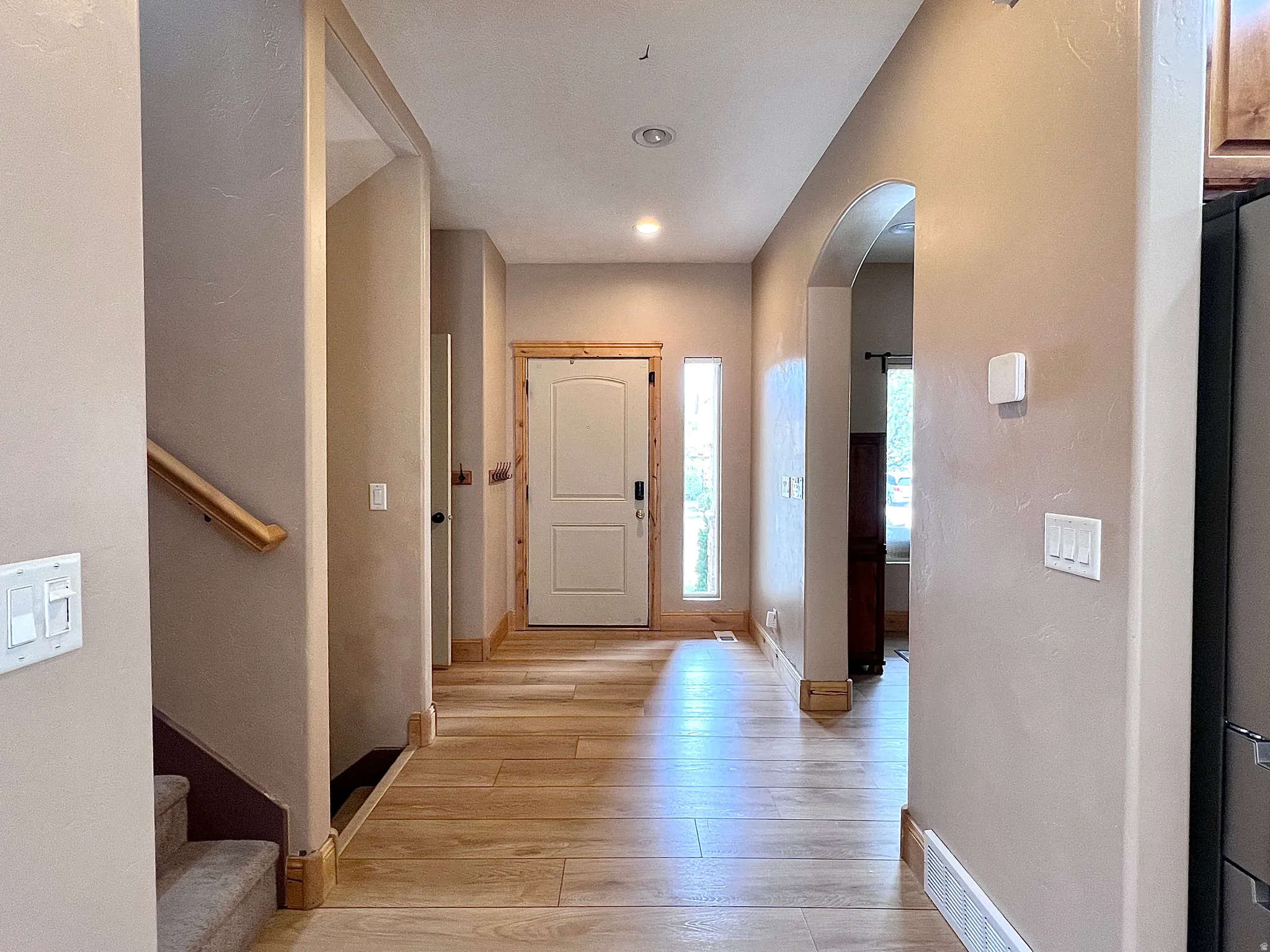 Entryway featuring arched walkways and light wood-type flooring