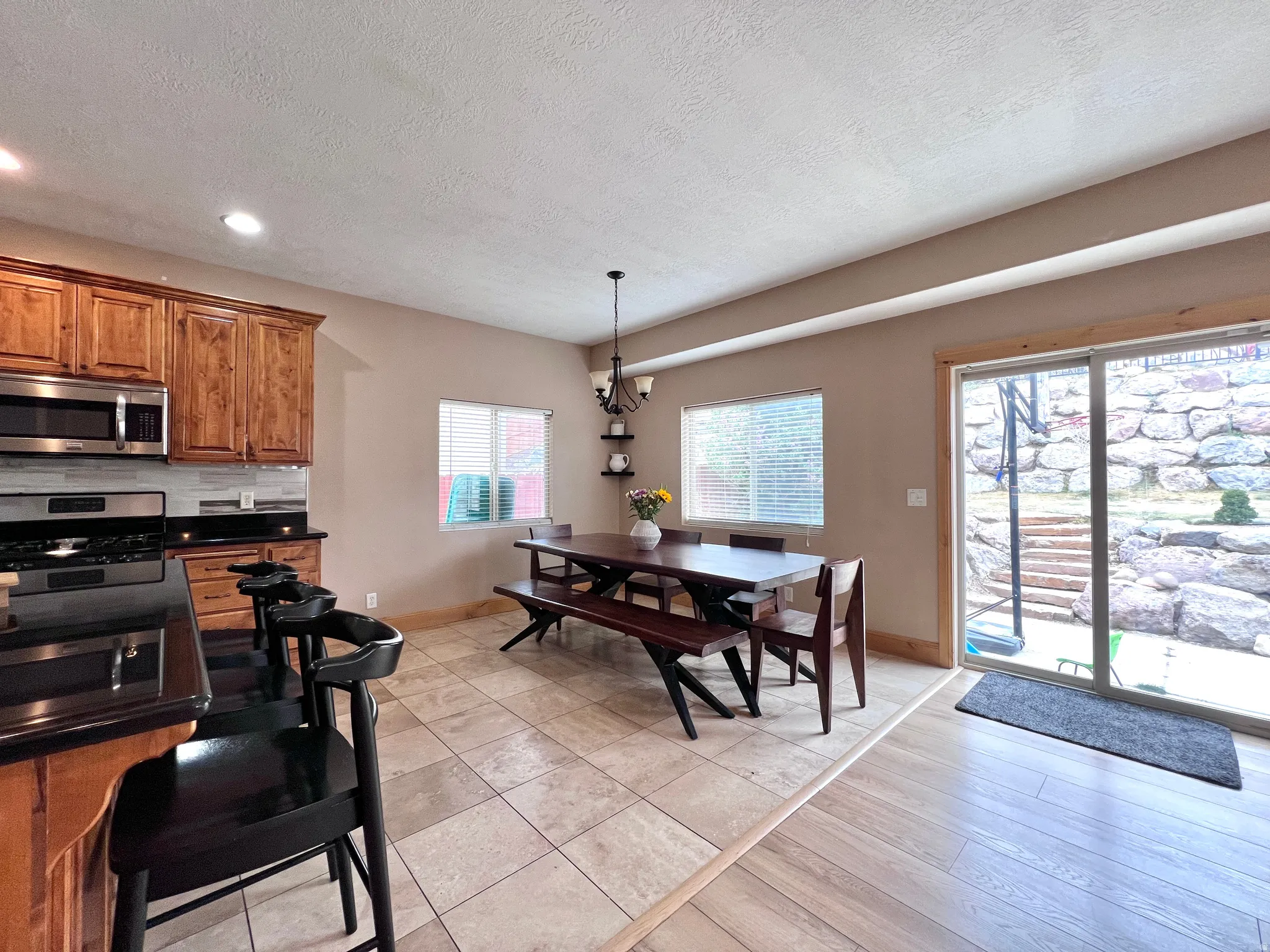 Dining space with light tile patterned floors, a textured ceiling, and a chandelier