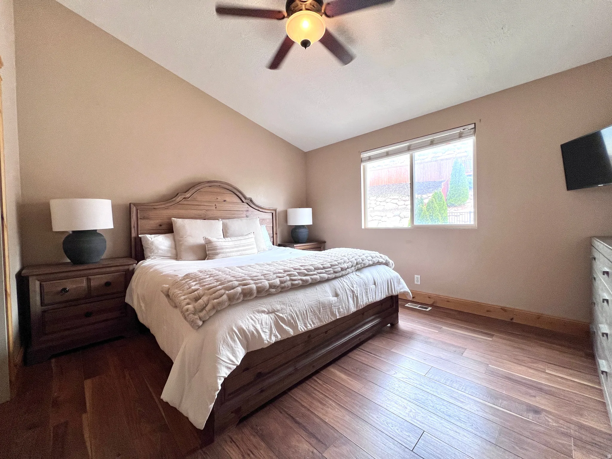 Bedroom featuring wood-type flooring, lofted ceiling, and ceiling fan