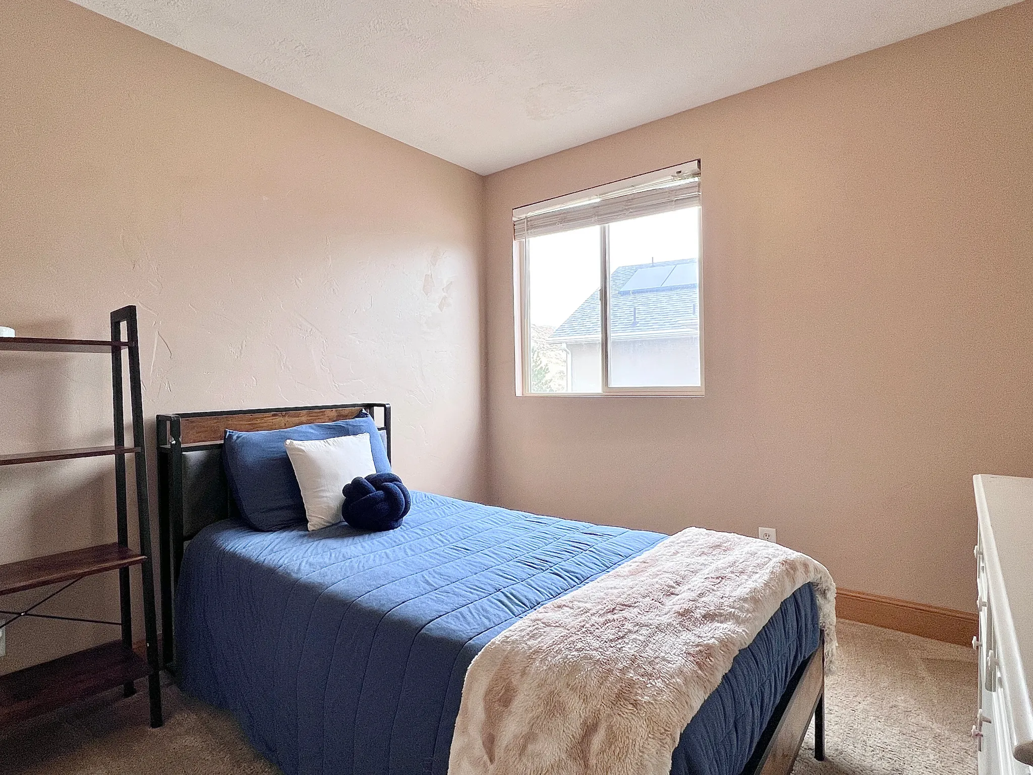 Carpeted bedroom with baseboards and a textured wall