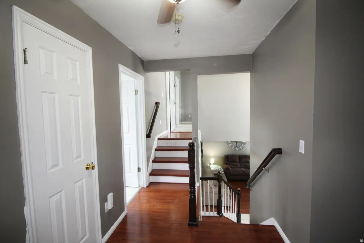 Stairs with ceiling fan and wood finished floors