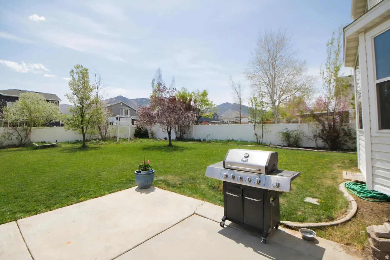 Fenced backyard with a patio, a grill, and a residential view