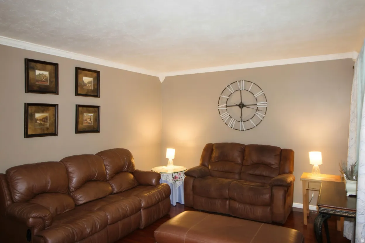 Living area featuring wood finished floors and crown molding
