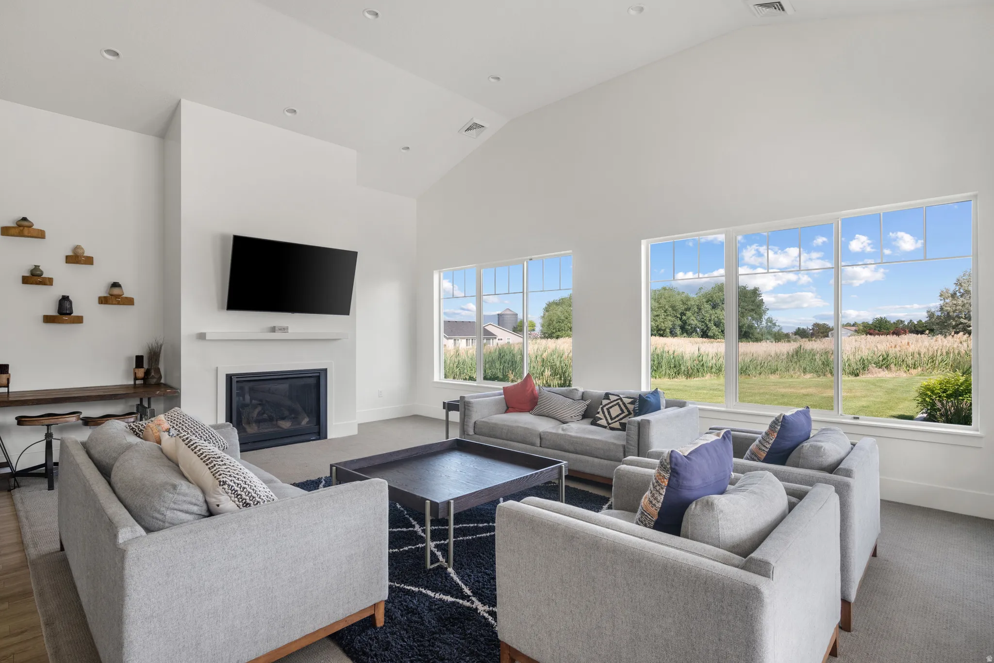 Living area with a glass covered fireplace and vaulted ceiling
