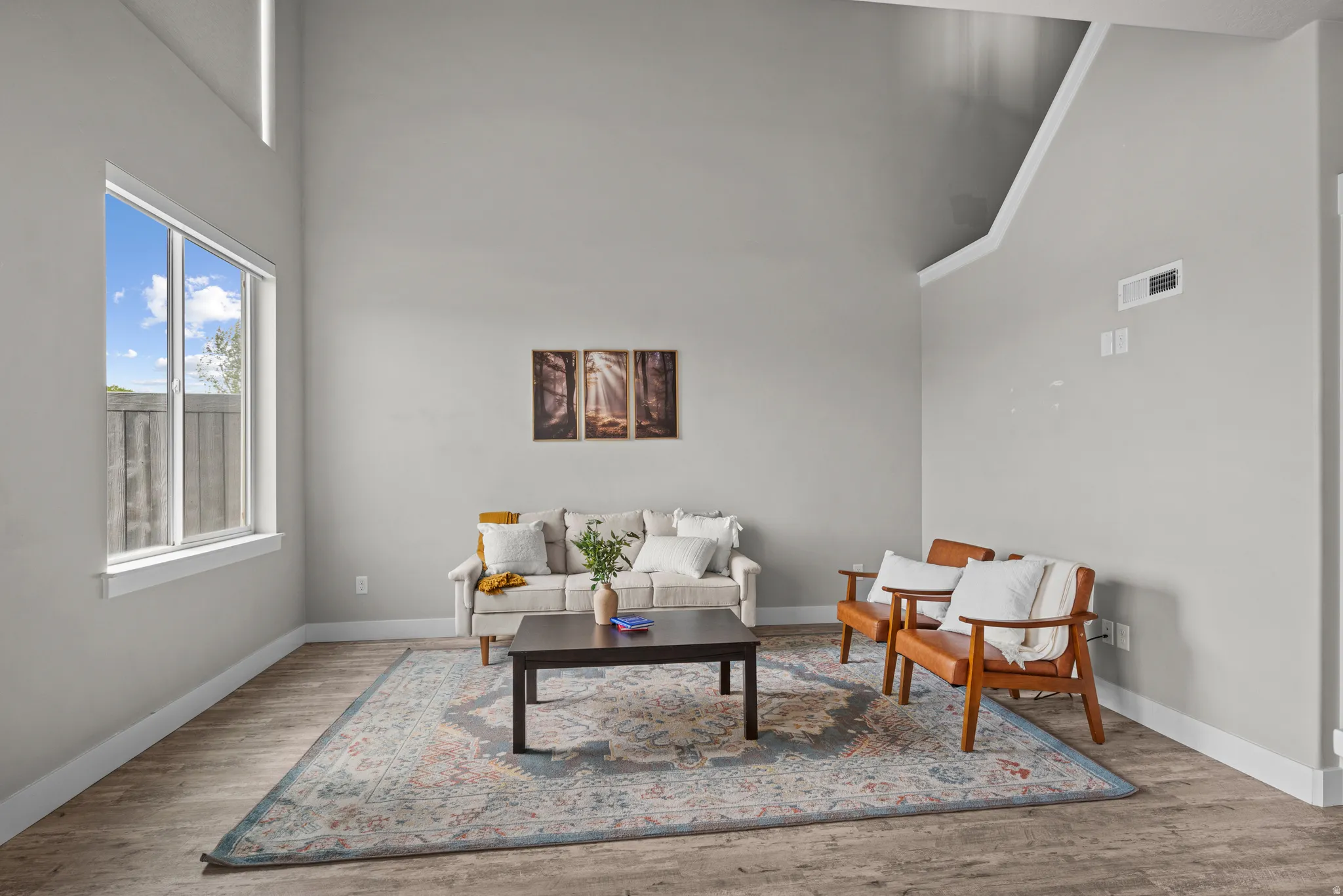 Living room featuring wood finished floors and a high ceiling