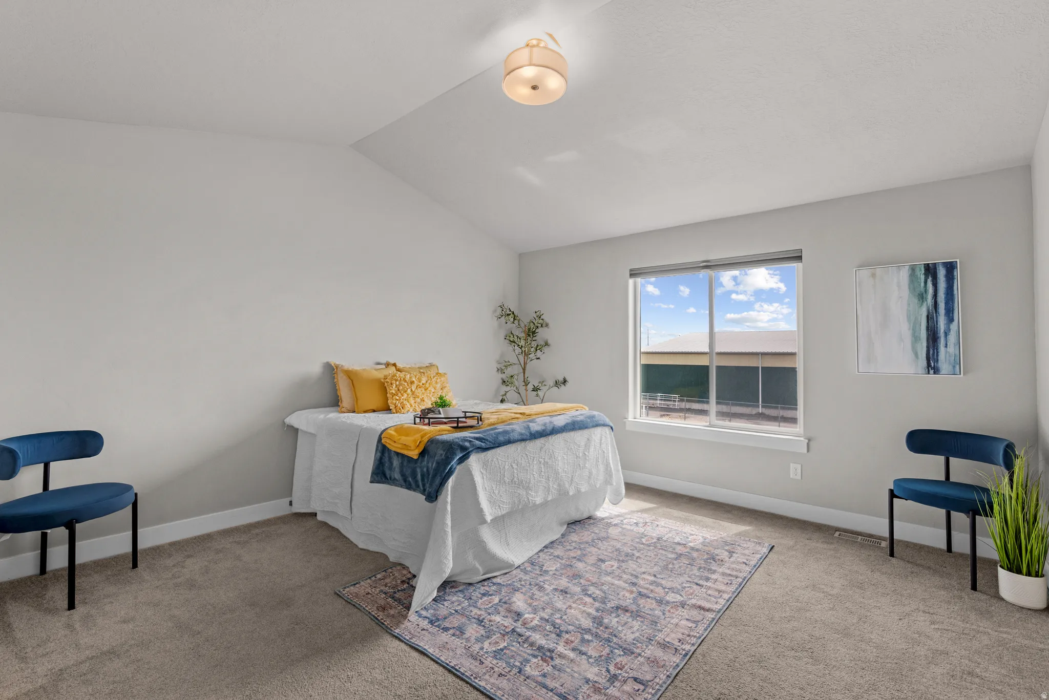 Bedroom with light colored carpet and lofted ceiling