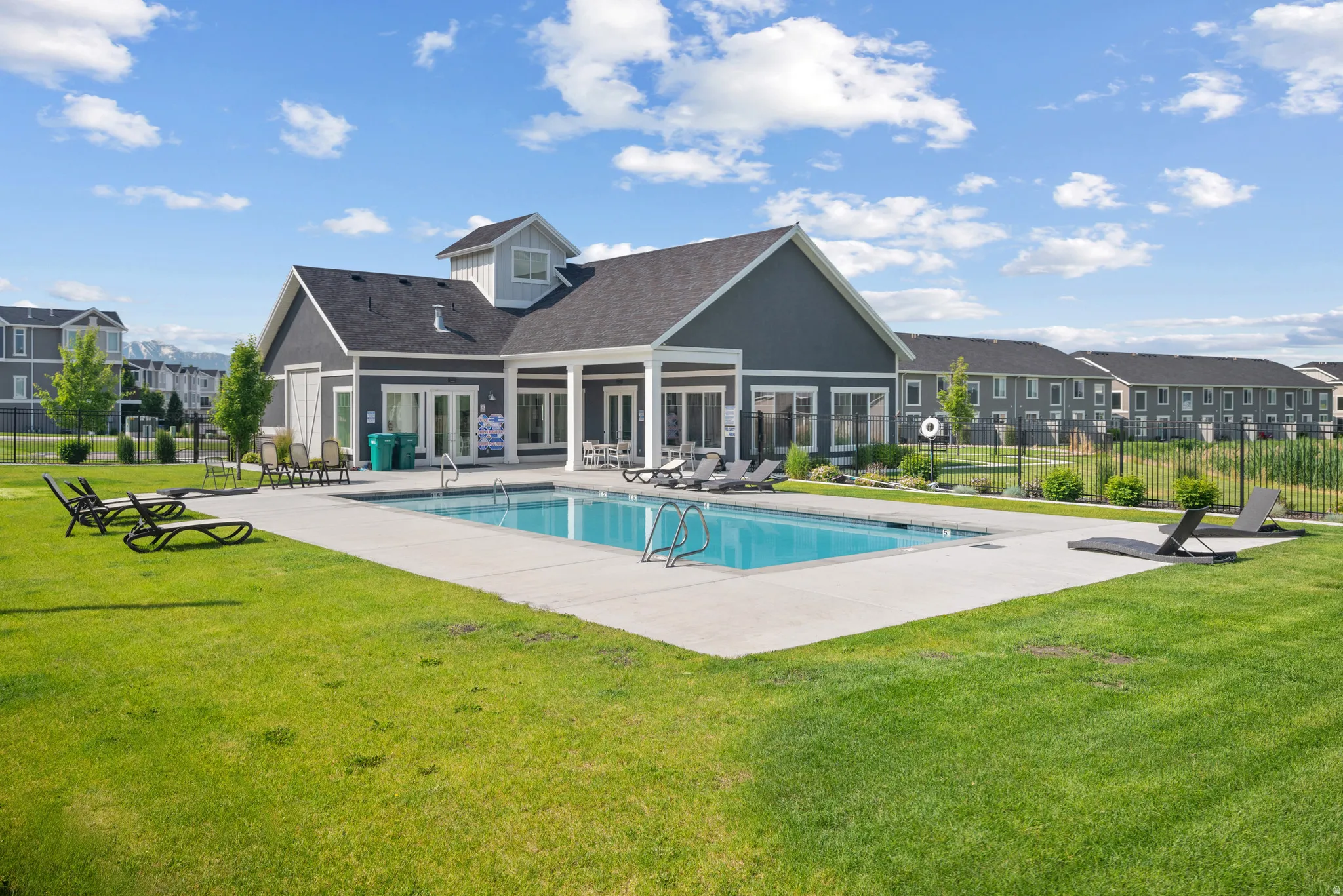 Community pool with a patio and a residential view